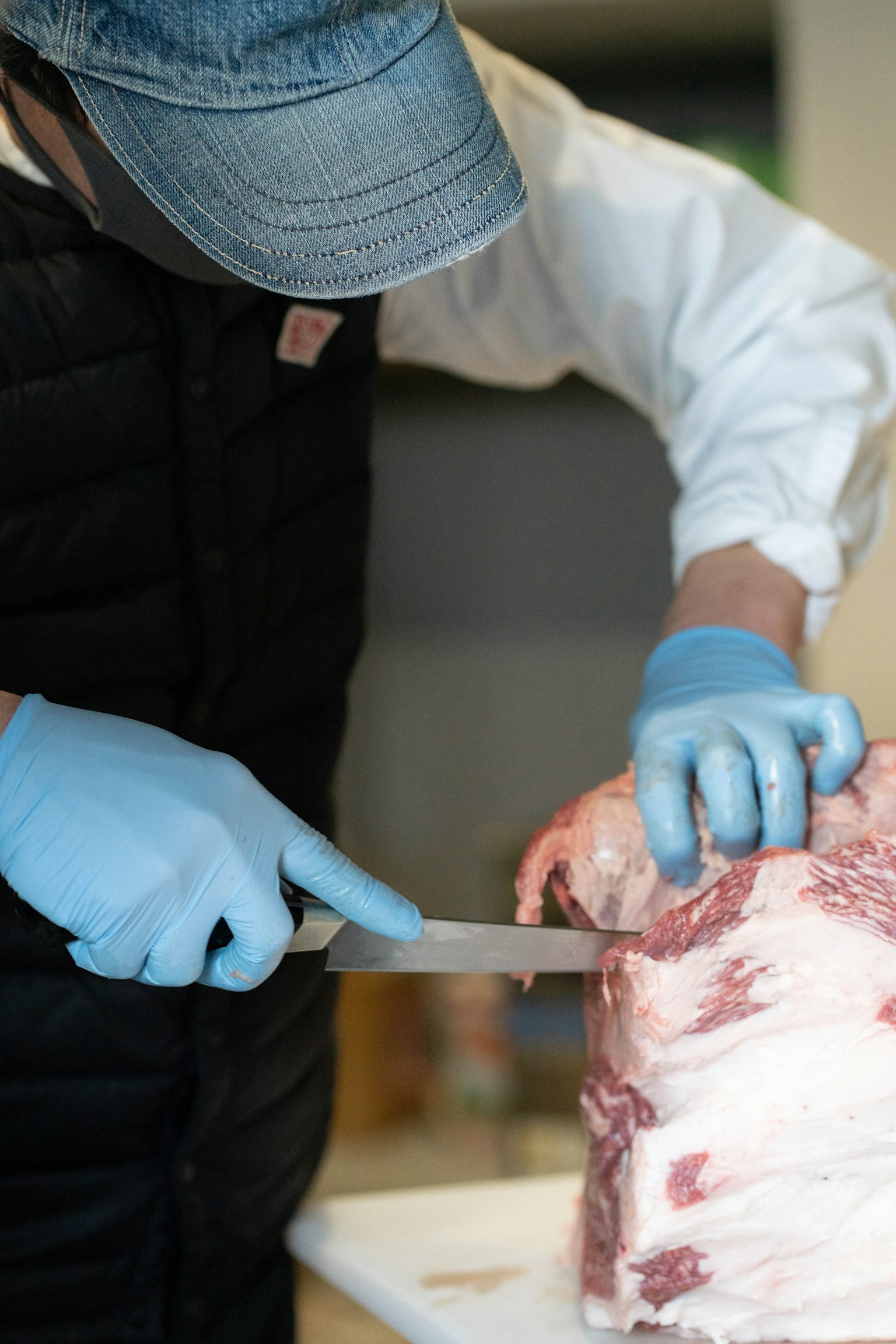正在用刀切肉的男人