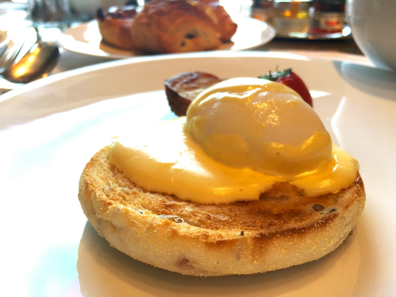 Piatto con muffin inglese guarnito con uovo in camicia e salsa olandese