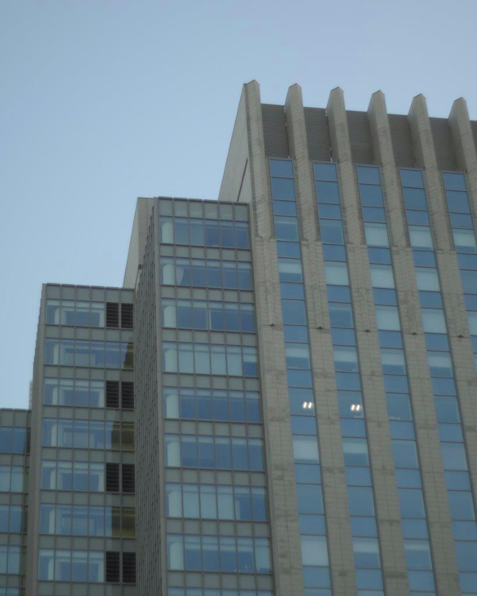 高层建筑顶部，配有玻璃窗和混凝土外立面