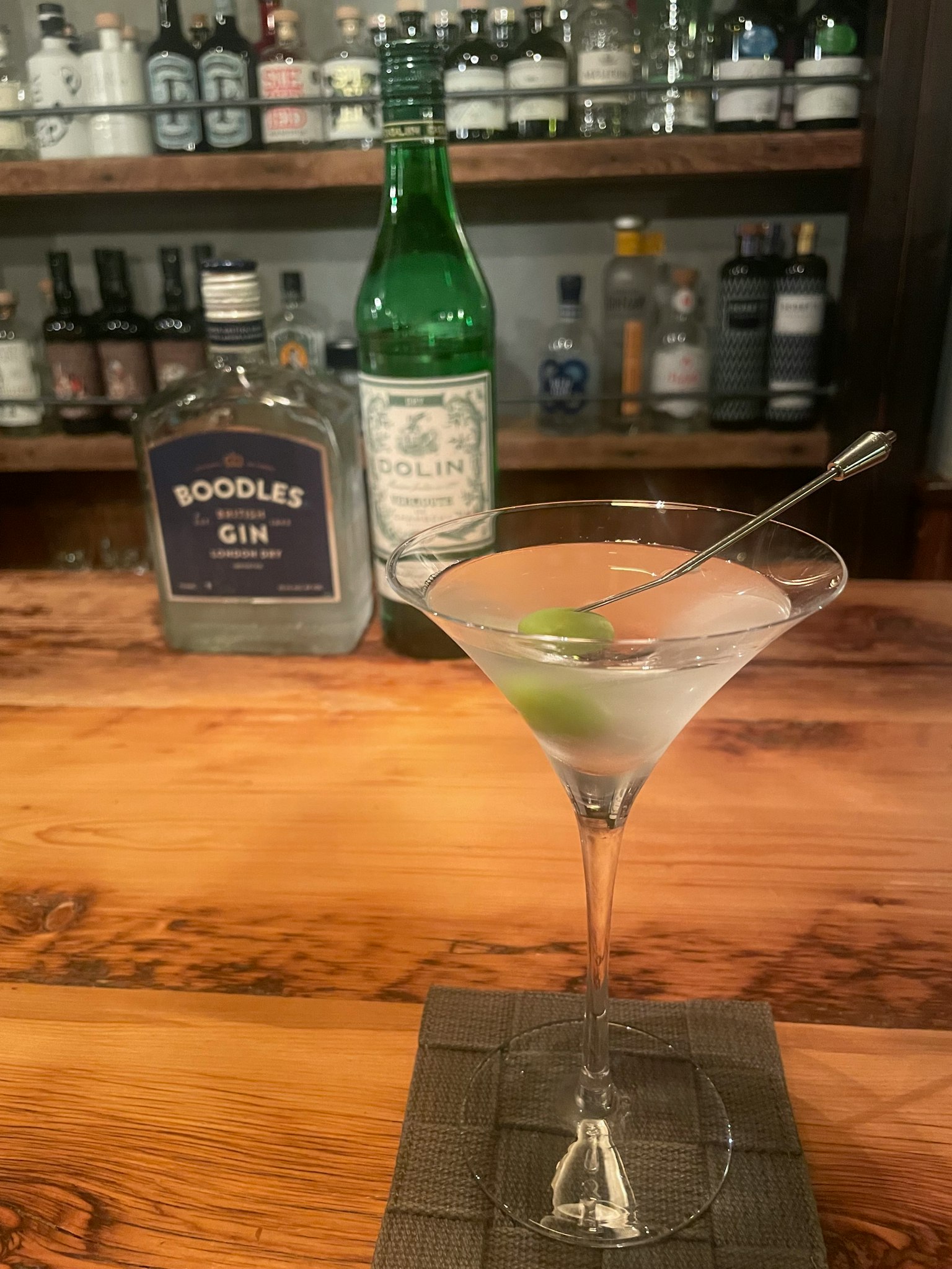 마티니 칵테일이 담긴 잔과 배경의 Boodles Gin 병