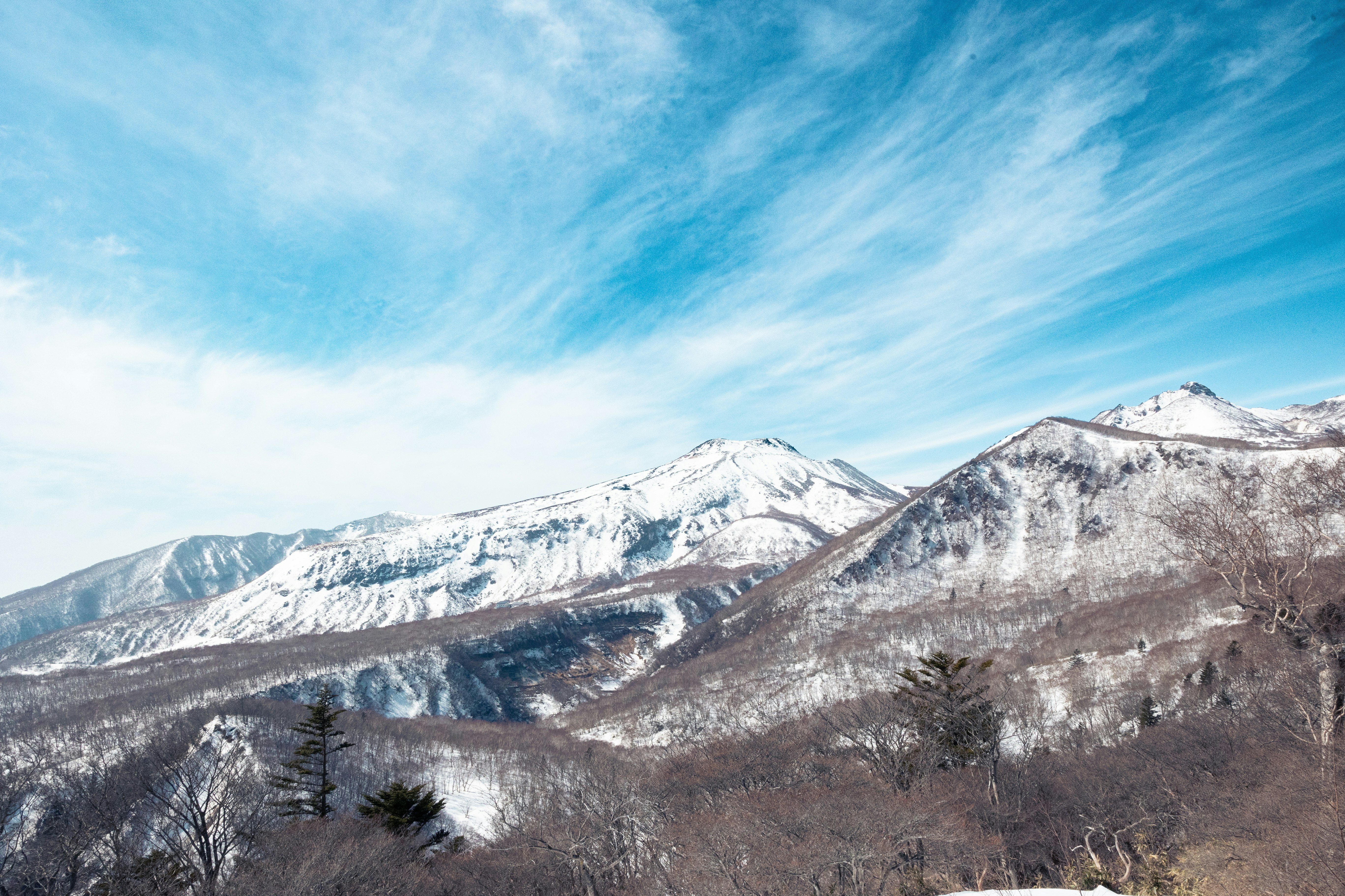 雪をかぶった山並みと広がる青空の風景