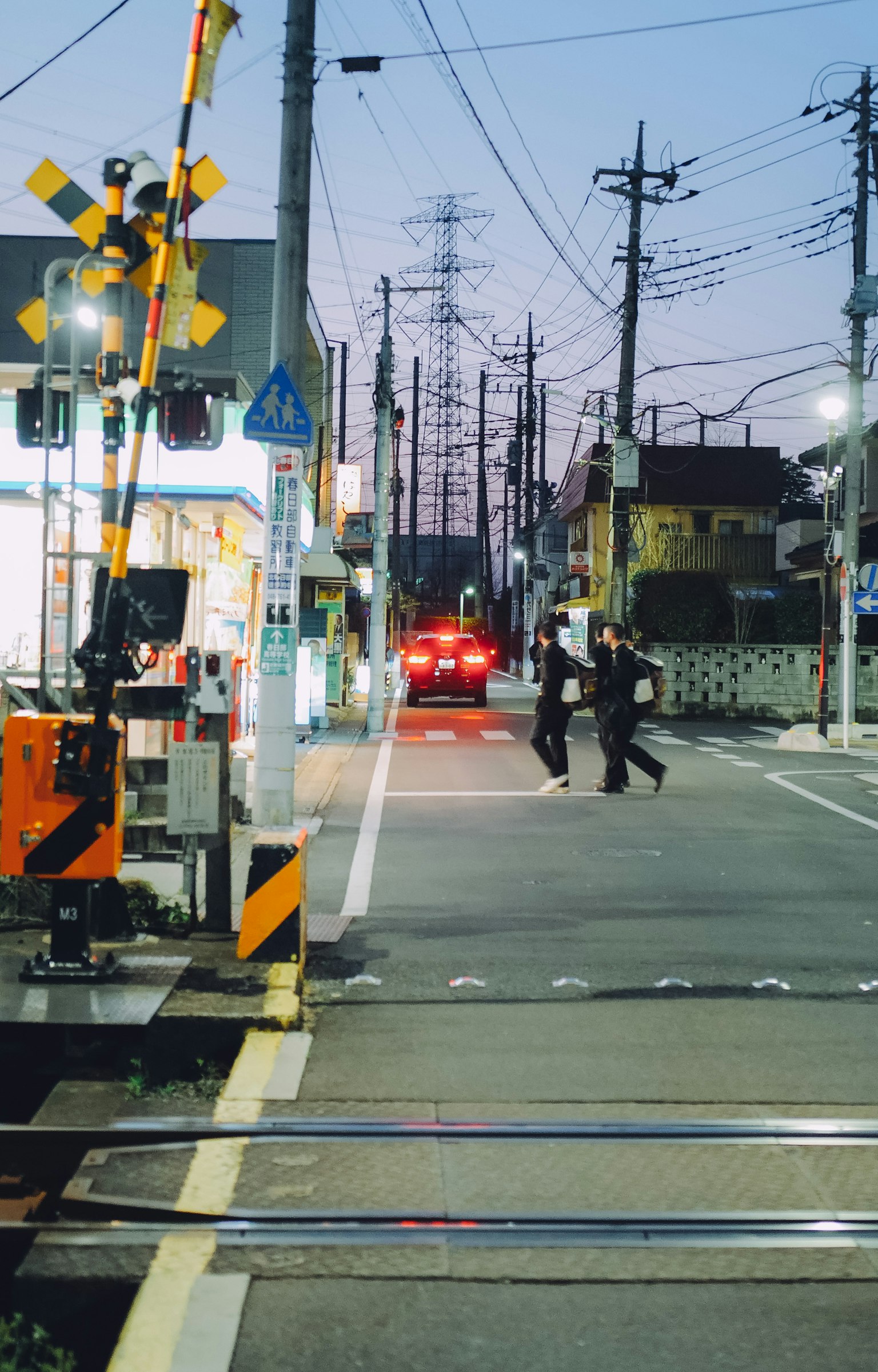 黃昏時分在鐵路交叉口過馬路的行人