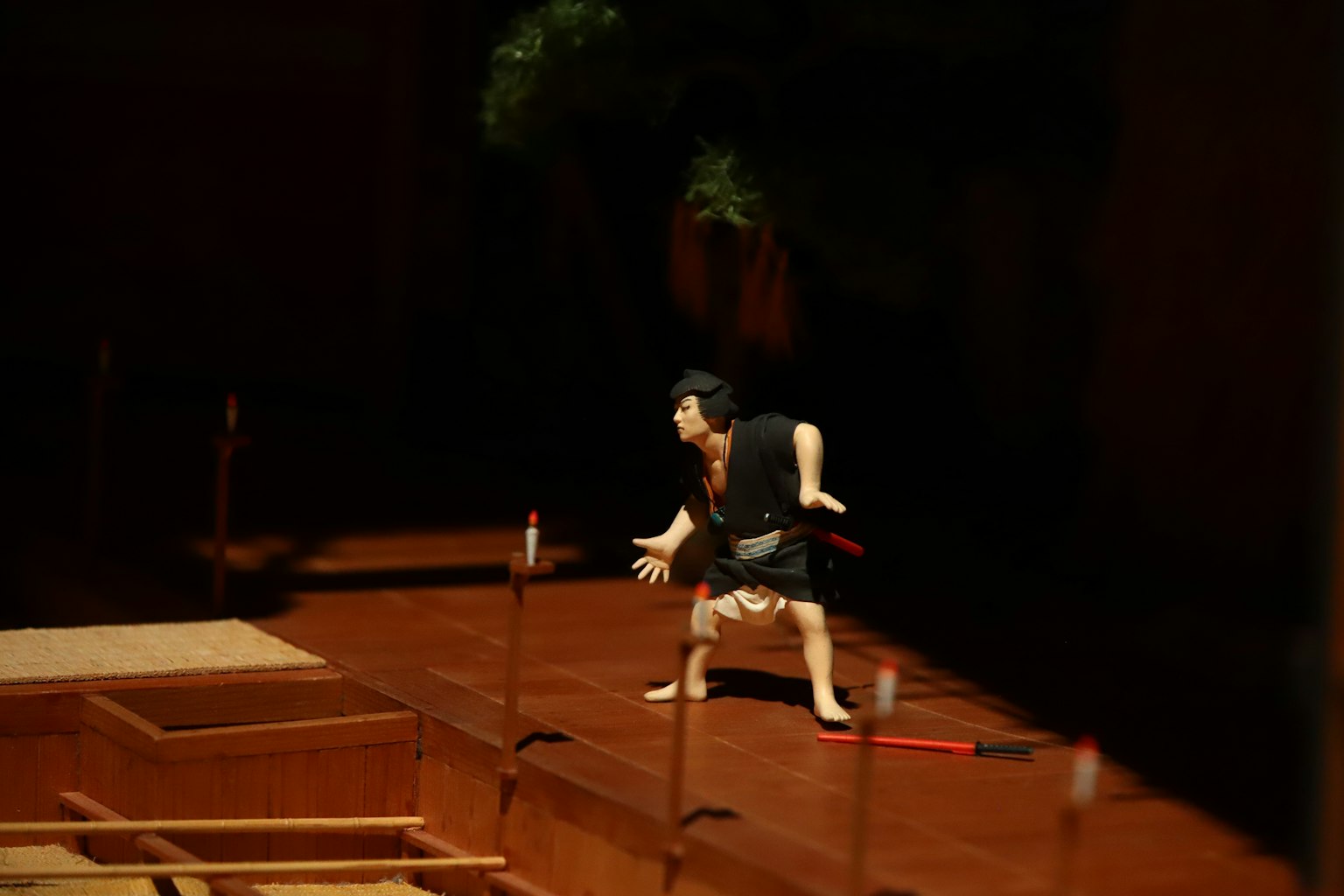 Una marioneta adoptando una pose en un escenario de madera