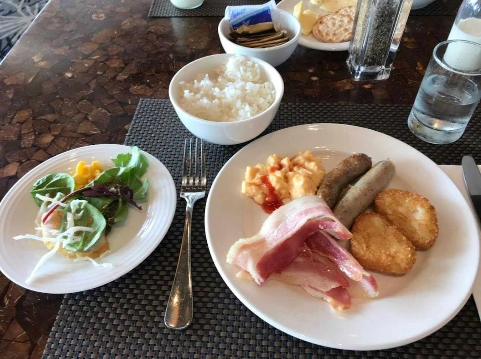 Piatto di colazione con una varietà di piatti insalata riso prosciutto salsiccia