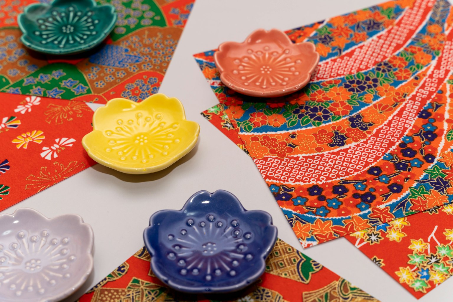 Pequeños platos coloridos y hermoso papel estampado dispuestos juntos