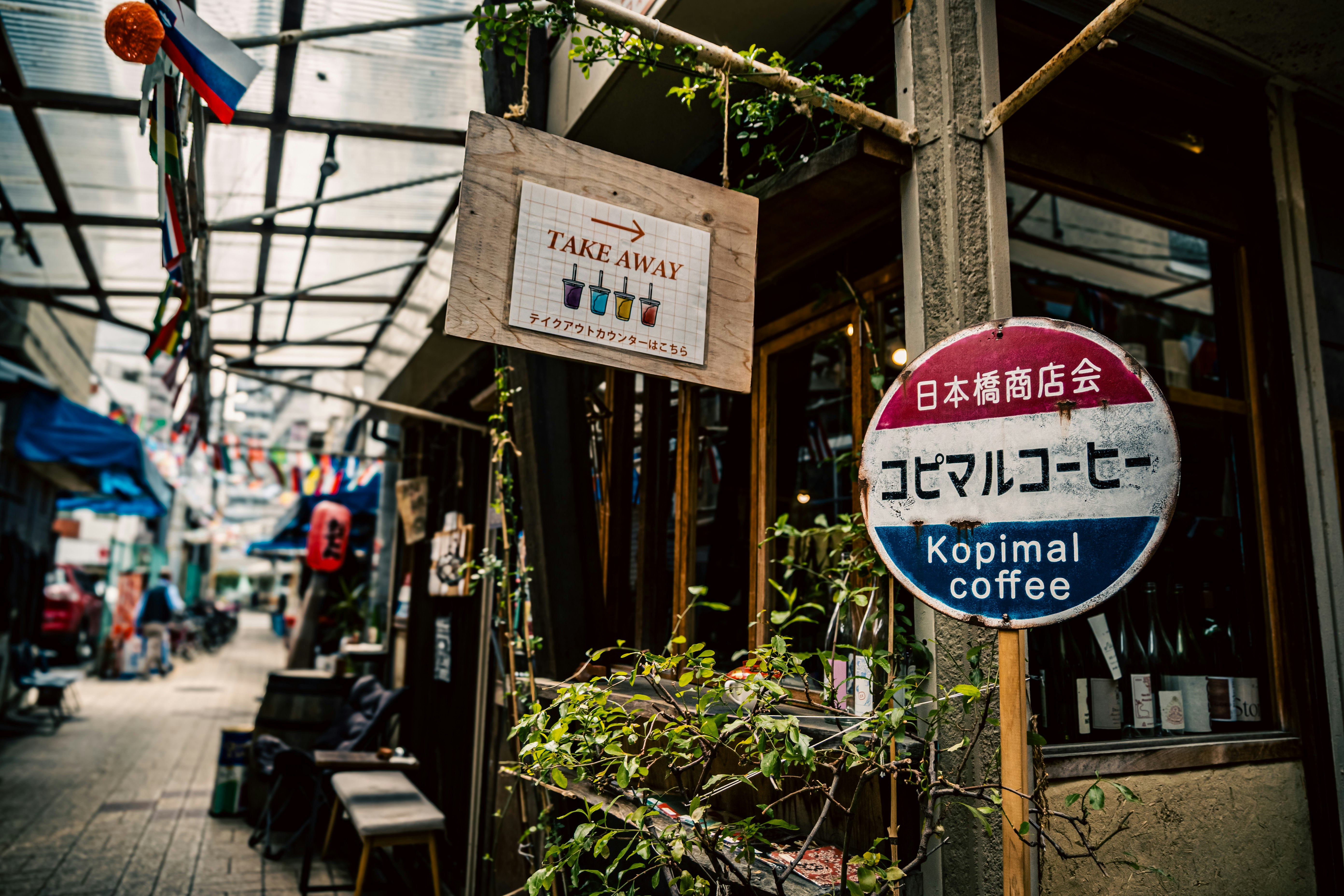 路地の店先に並ぶ看板とコーヒーのメニュー画像