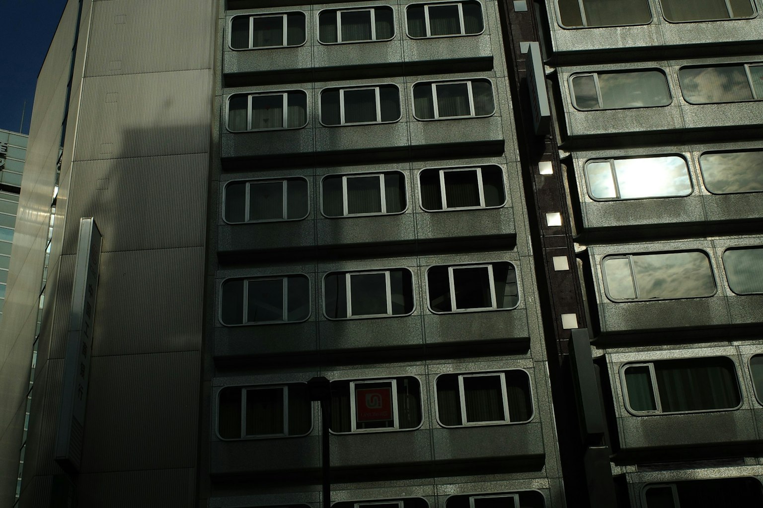 Modern building facade with reflective windows and shadows