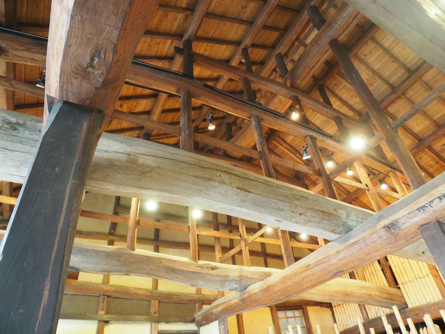 传统木建筑内部视图，展示裸露的梁