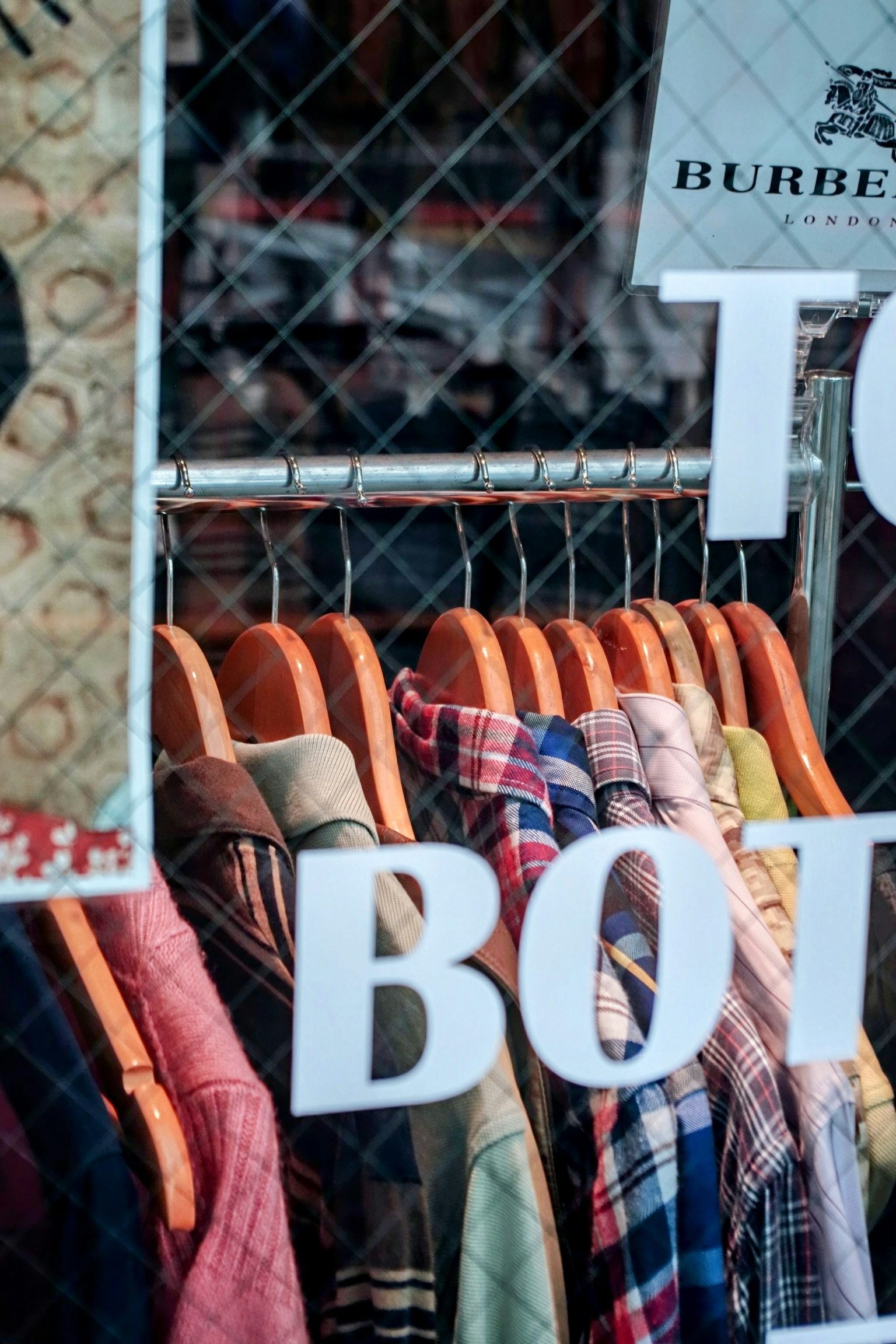 Vestes colorées accrochées à un portant dans une vitrine