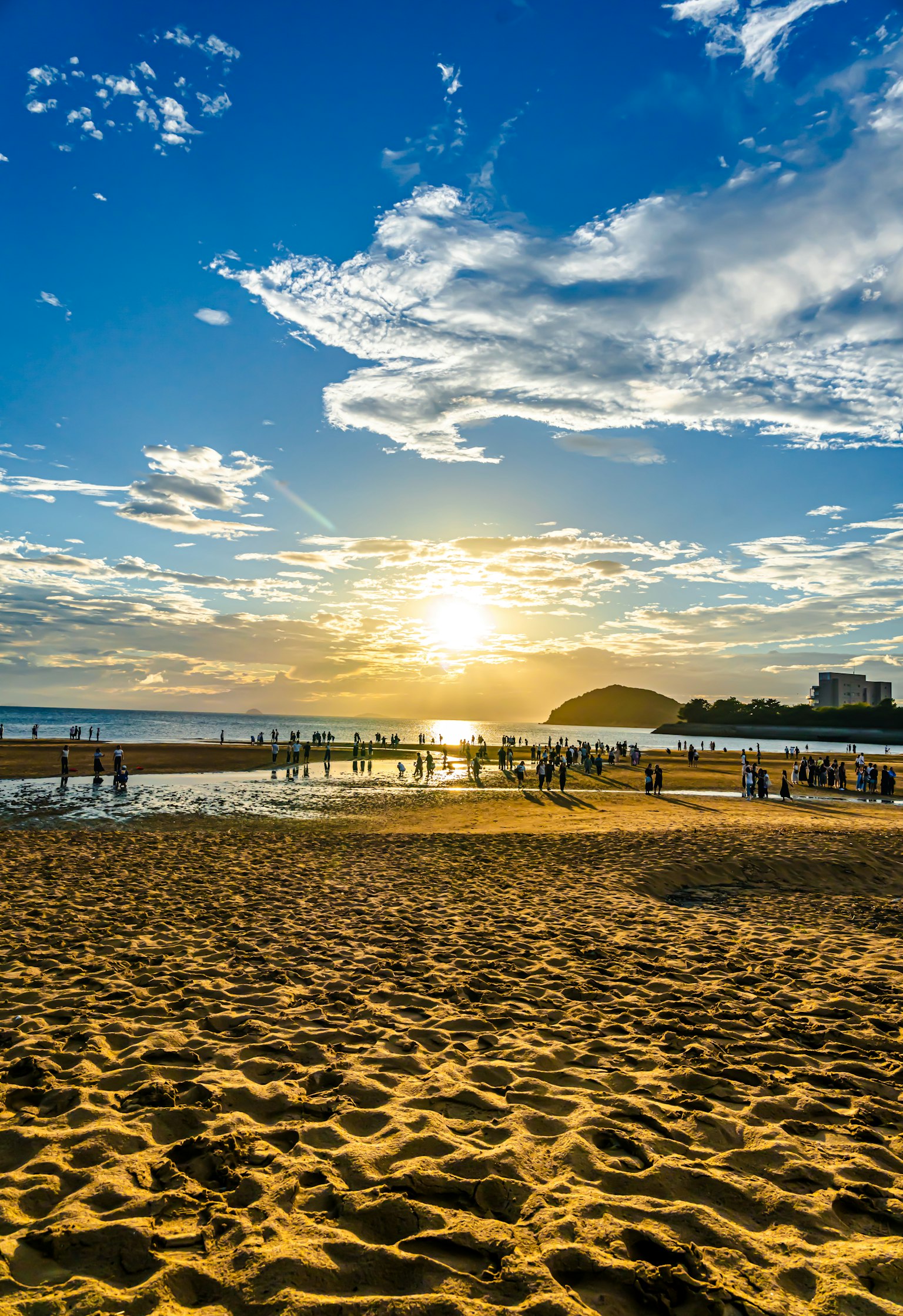 Sunset beach scene with golden sand and sea people enjoying the view