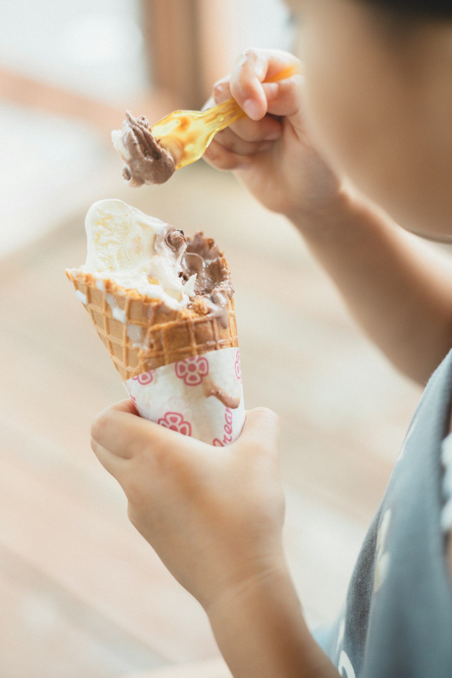 Child holding and eating an ice cream cone