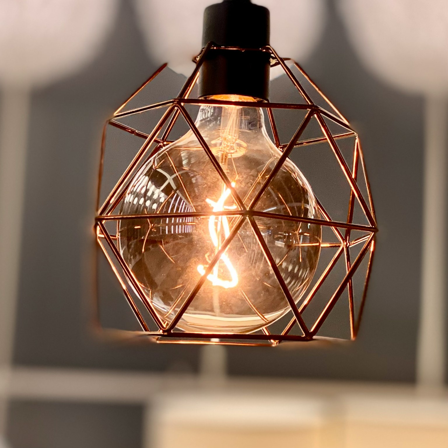 Lampada a sospensione geometrica con una lampadina brillante