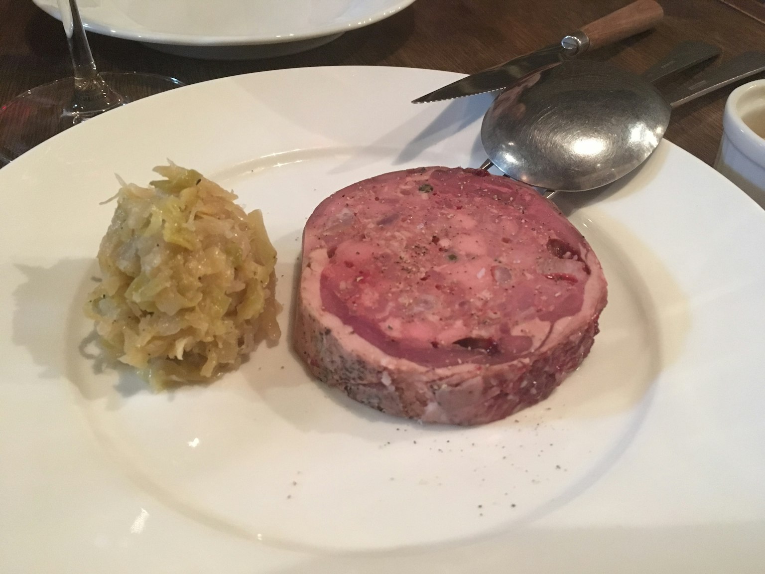 盤子上放著一片肉餡餅和旁邊的高麗菜