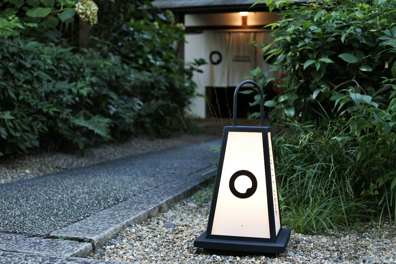 Lanterna in stile giapponese che illumina un sentiero nel giardino