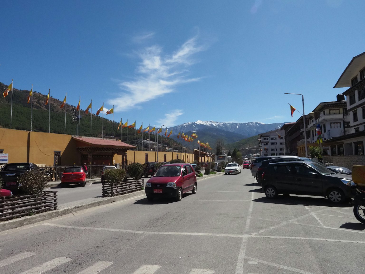 Vue de rue avec des voitures et des bâtiments sous un ciel bleu