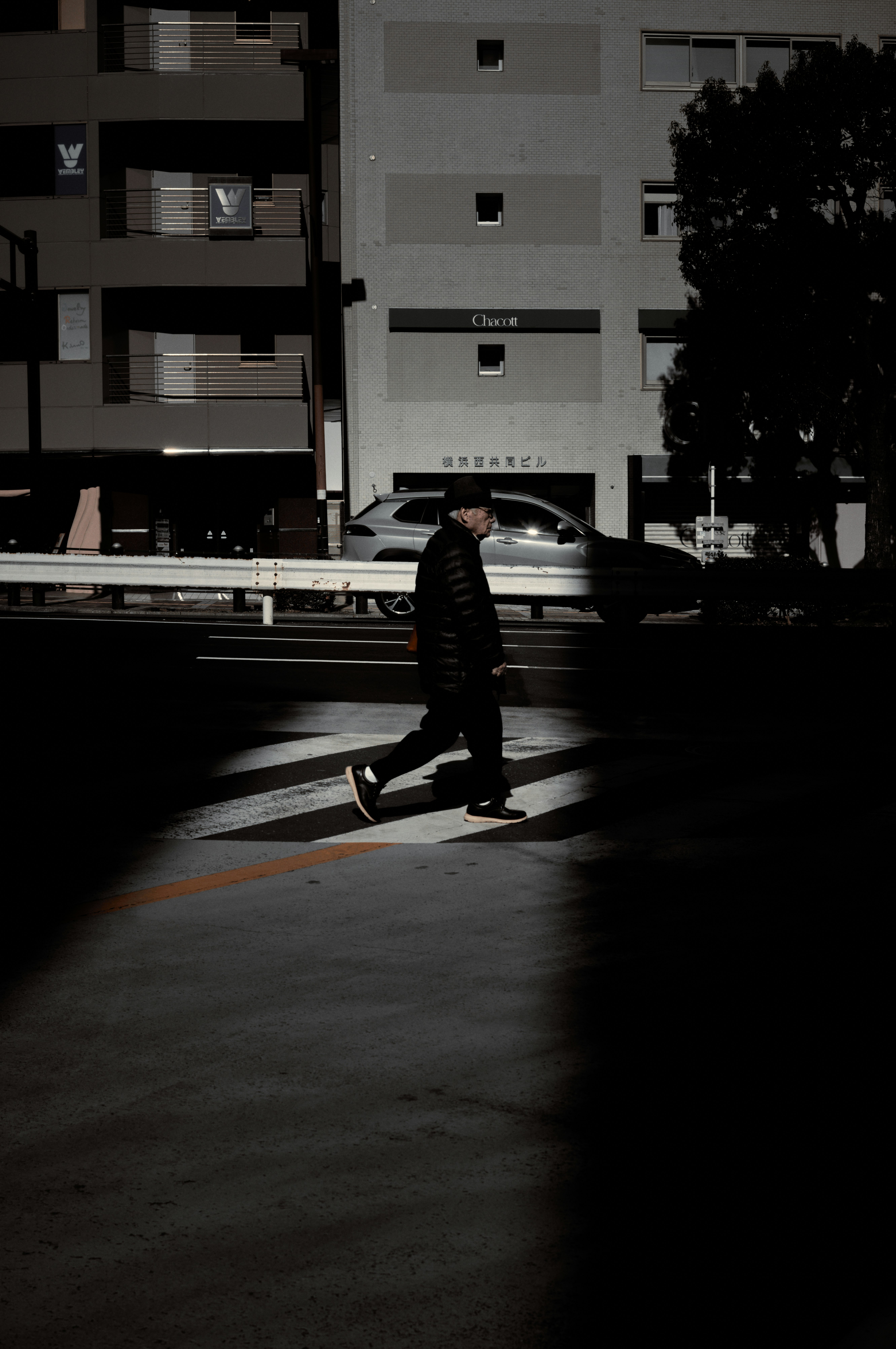 横断歩道のある街角で歩く人物