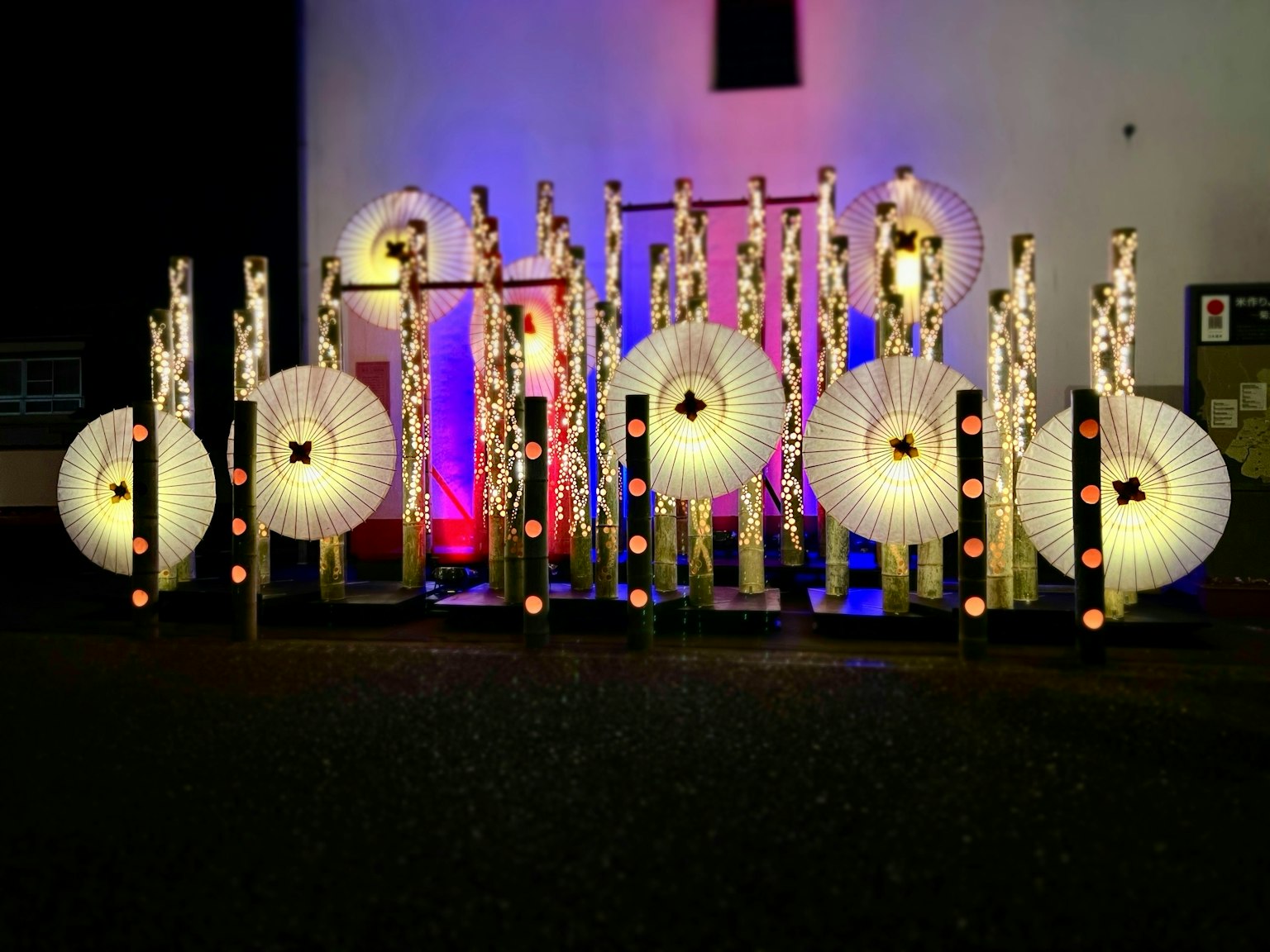 Exhibición decorativa de faroles blancos y luces coloridas de noche