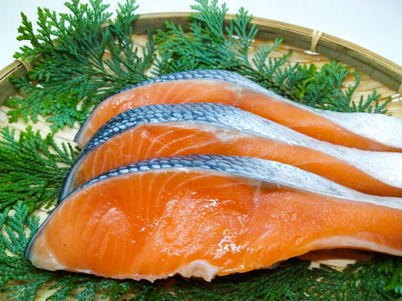 Filetes de salmón dispuestos sobre hojas verdes