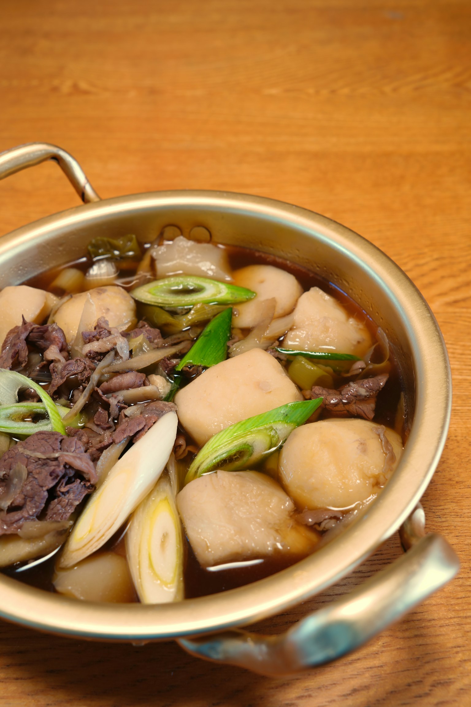 Sebuah panci sup daging dan lobak dengan daun bawang