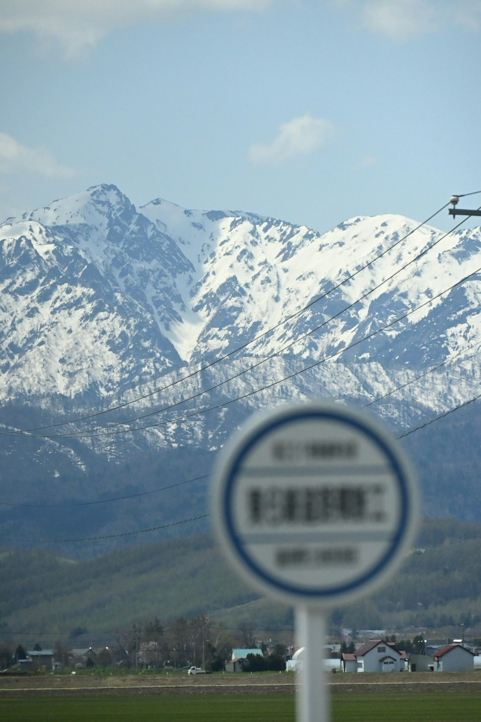 눈 덮인 산과 앞에 버스 정류장 표지판이 있는 경치