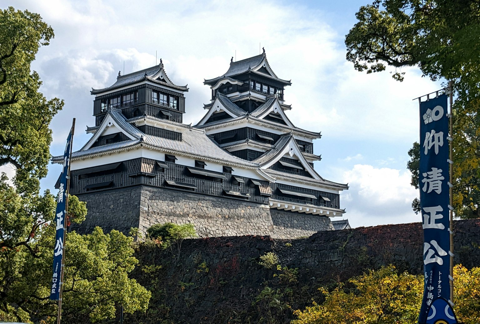 The beautiful exterior of Kumamoto Castle with a lush green background