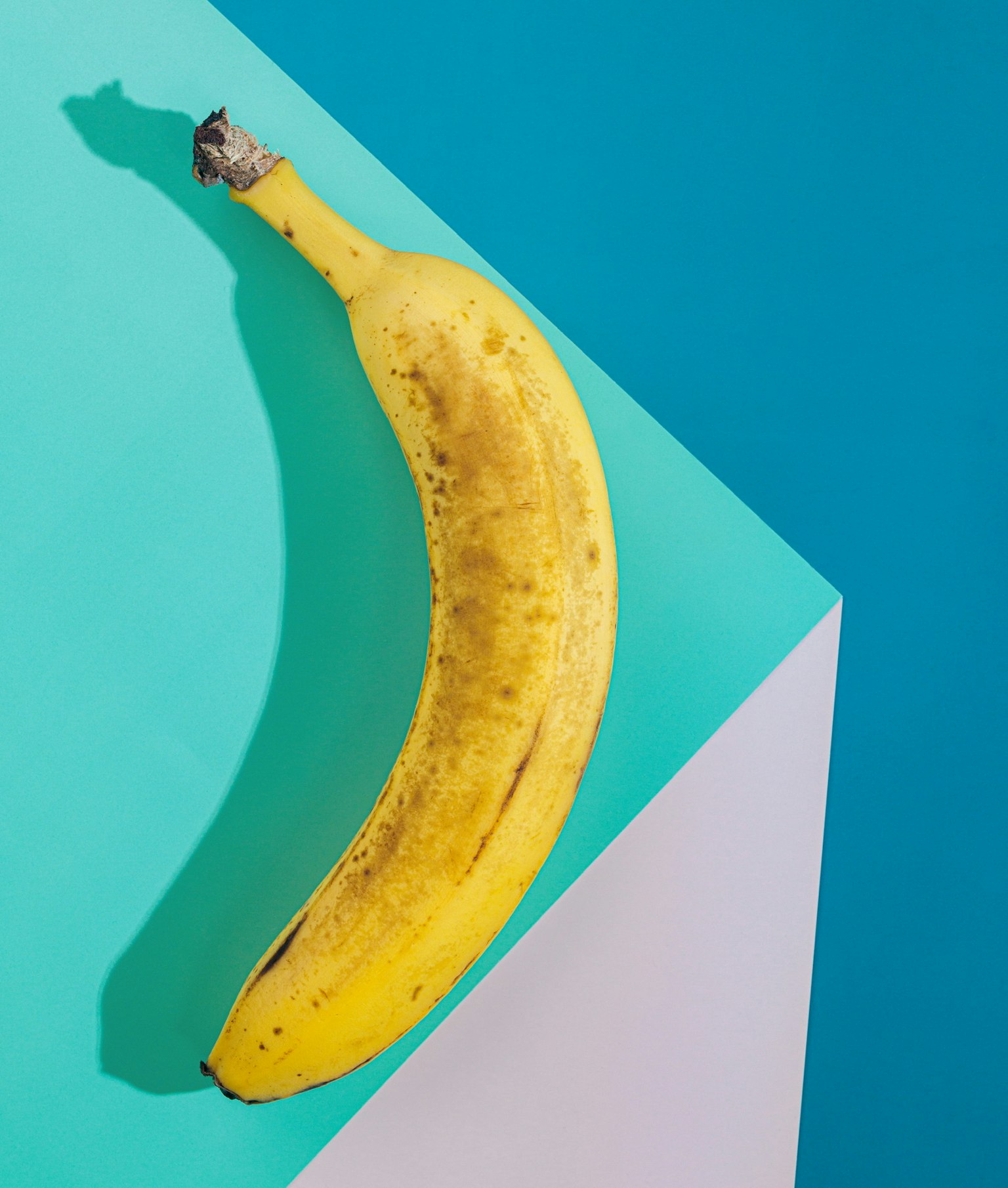 Gelbe Banane auf einem lebhaften blauen Hintergrund