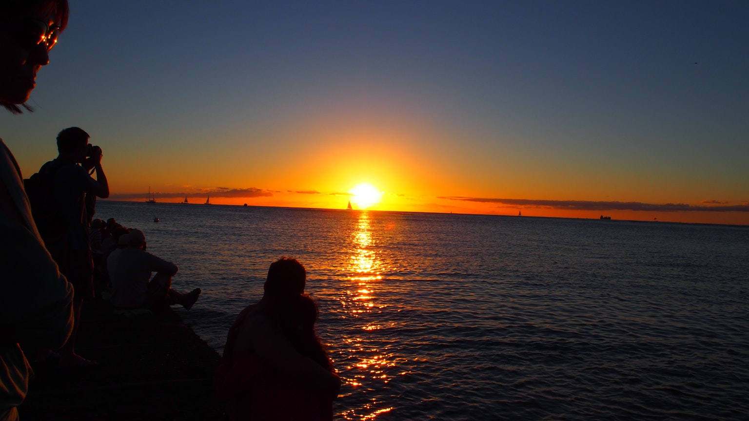 Bellissimo tramonto sull'oceano con silhouette di persone