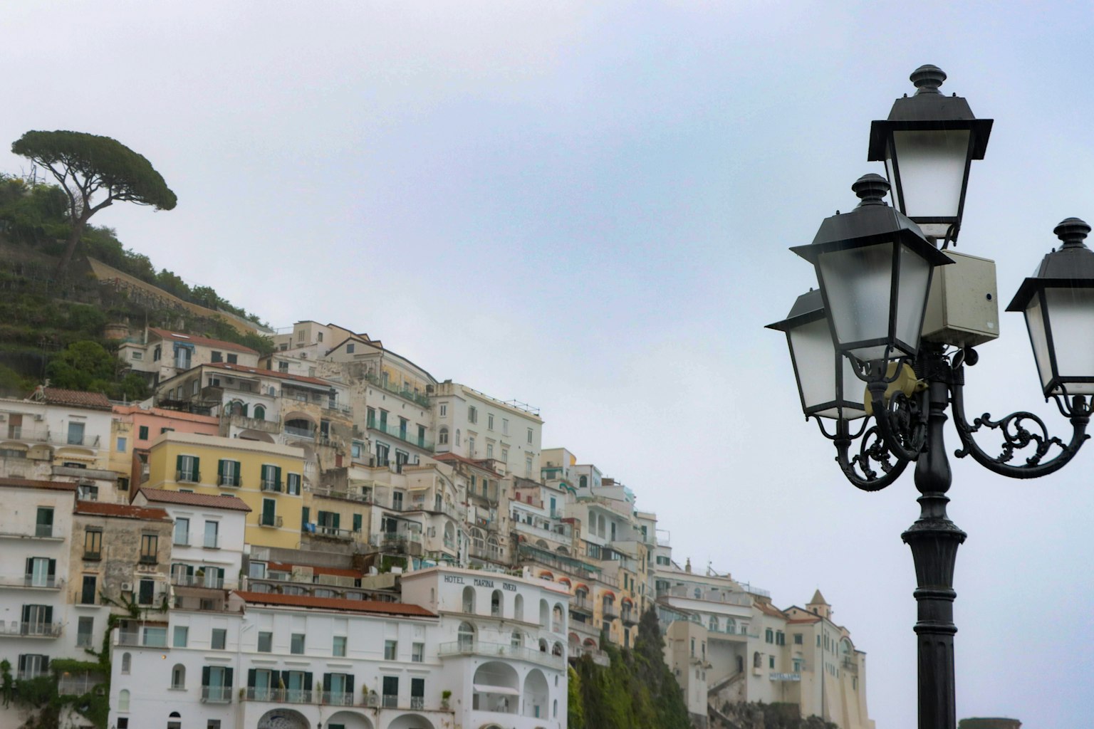 Casas coloridas a lo largo de la colina de Amalfi con una farola