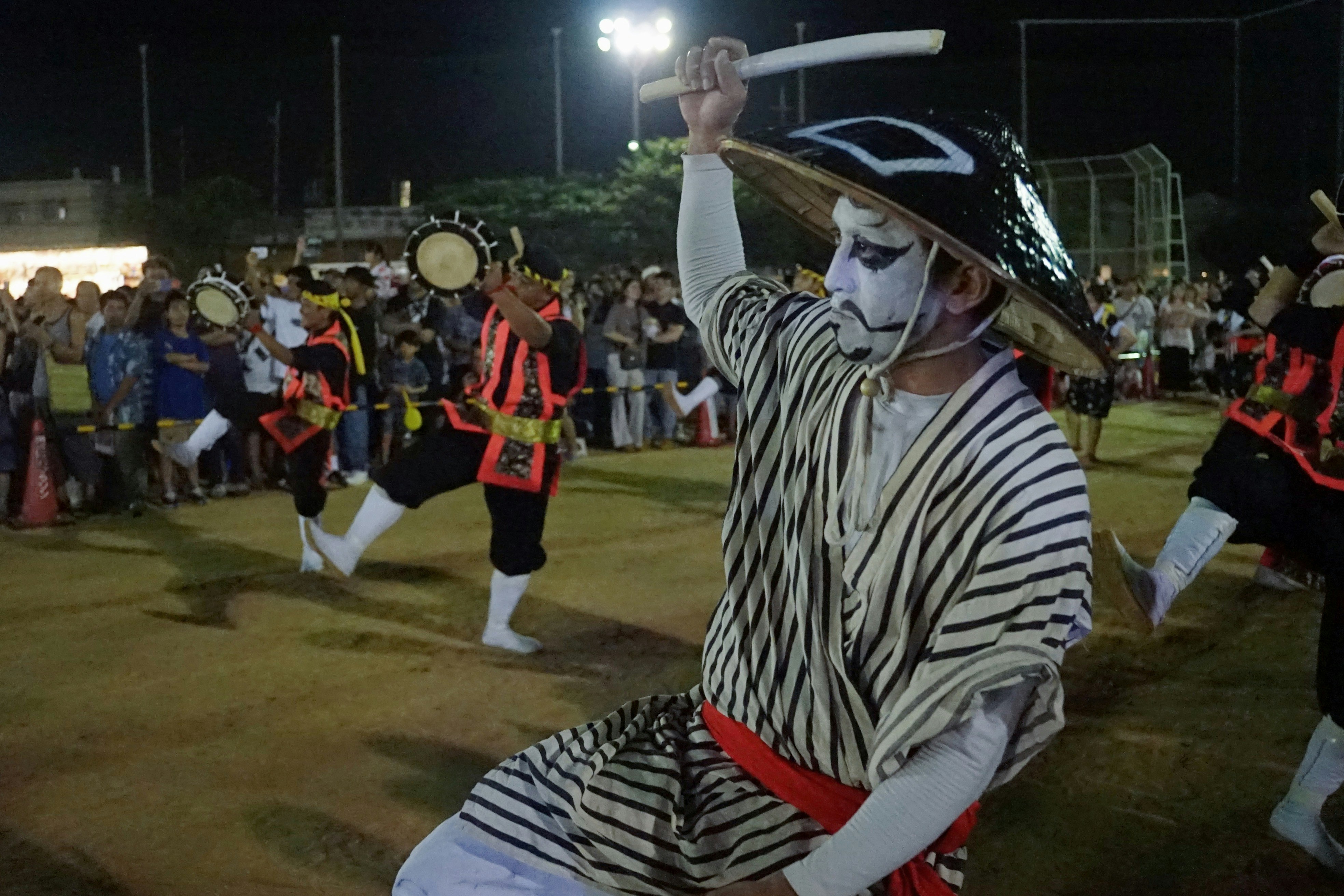 夜の街で踊るエイサーの太鼓と三線の演舞