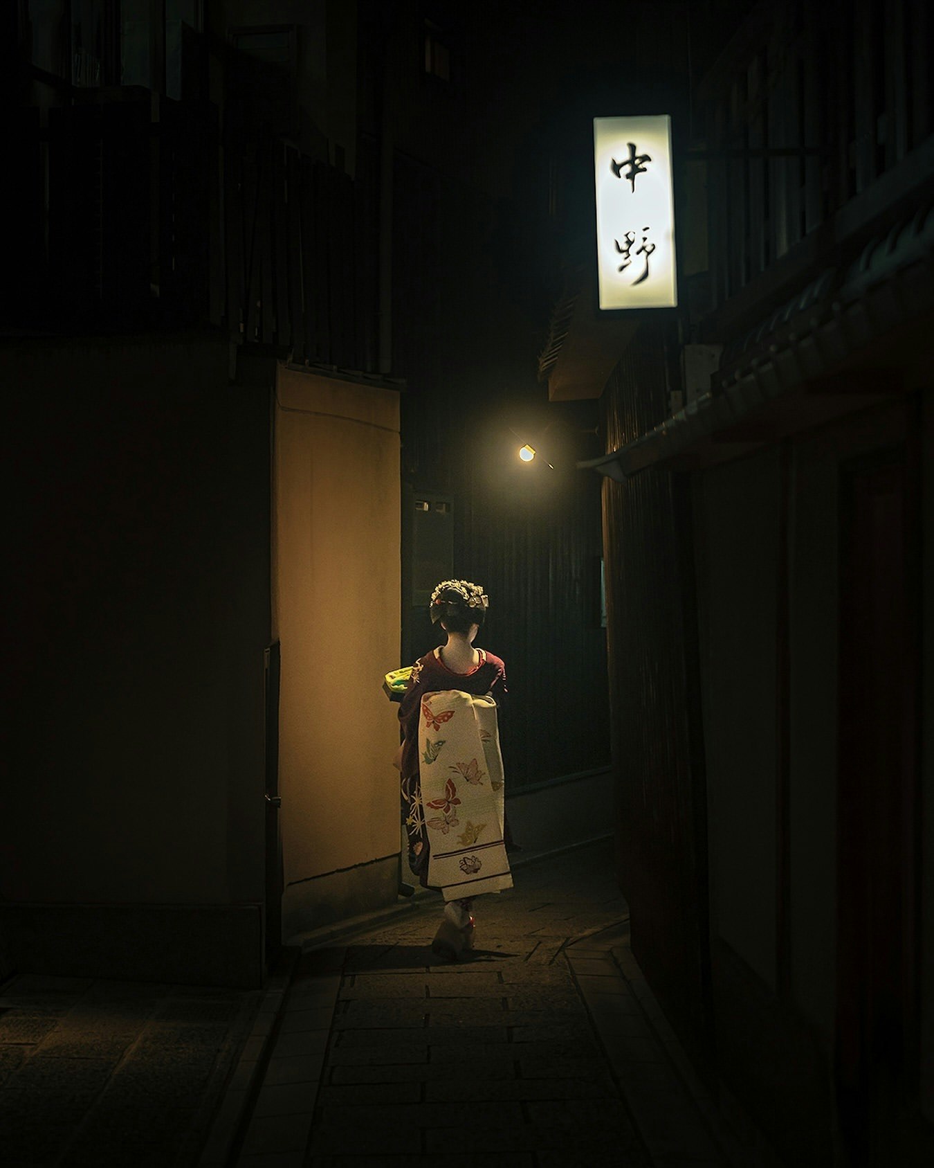 夜晚小巷里穿浴衣的孩子站在灯笼下