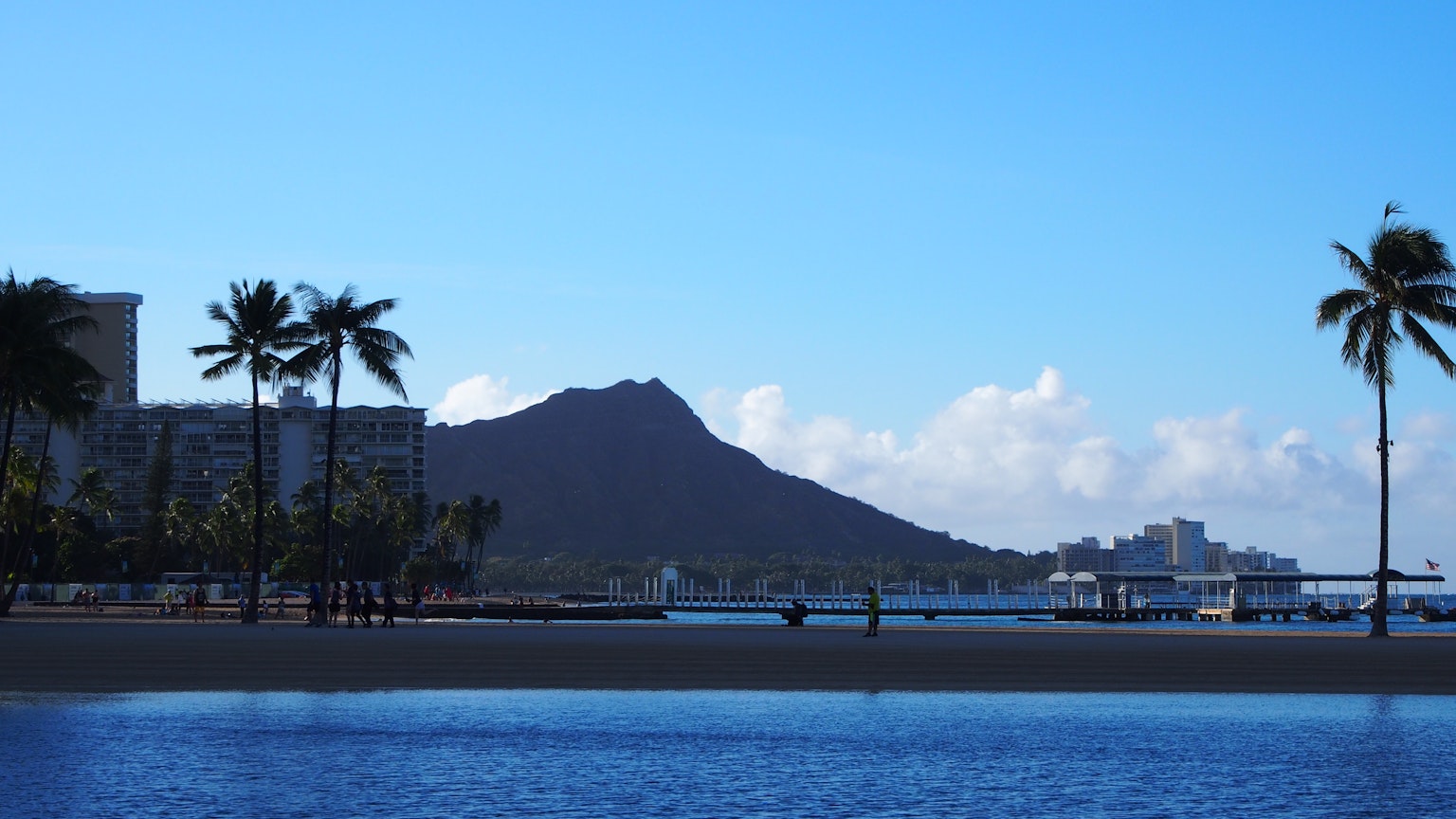 Scenic view of blue sky and ocean with Diamond Head in the background featuring Hawaiian beach and palm trees