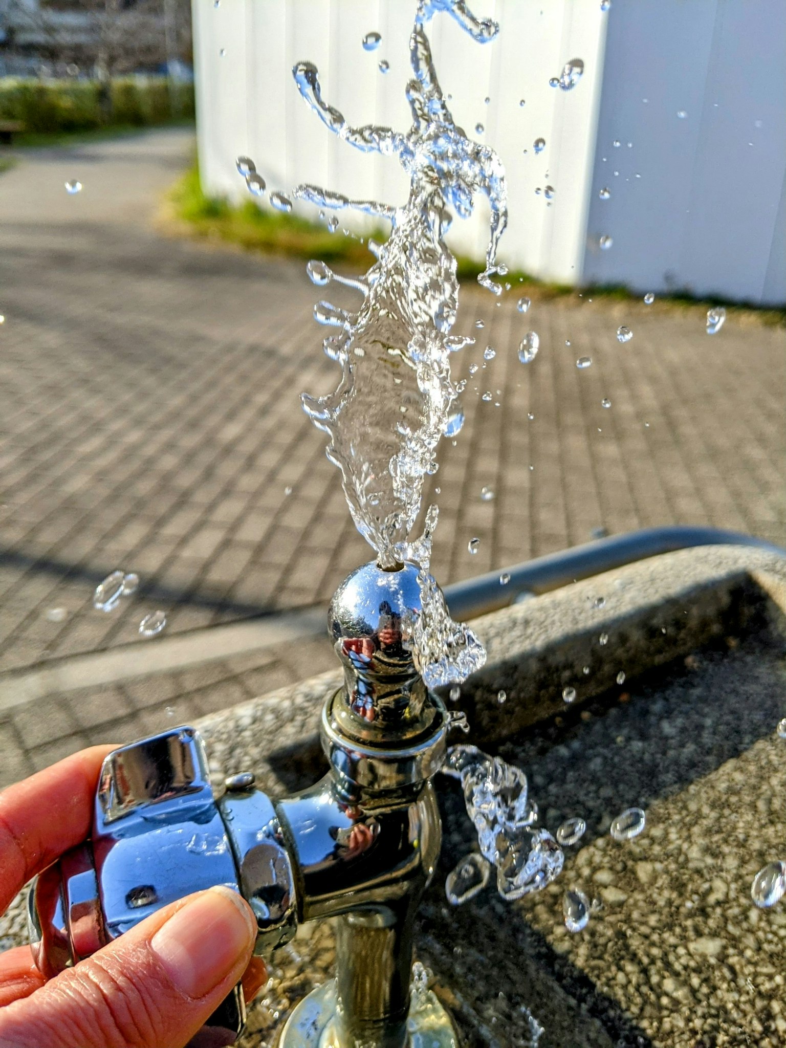 A close-up of a water faucet with water splashing out