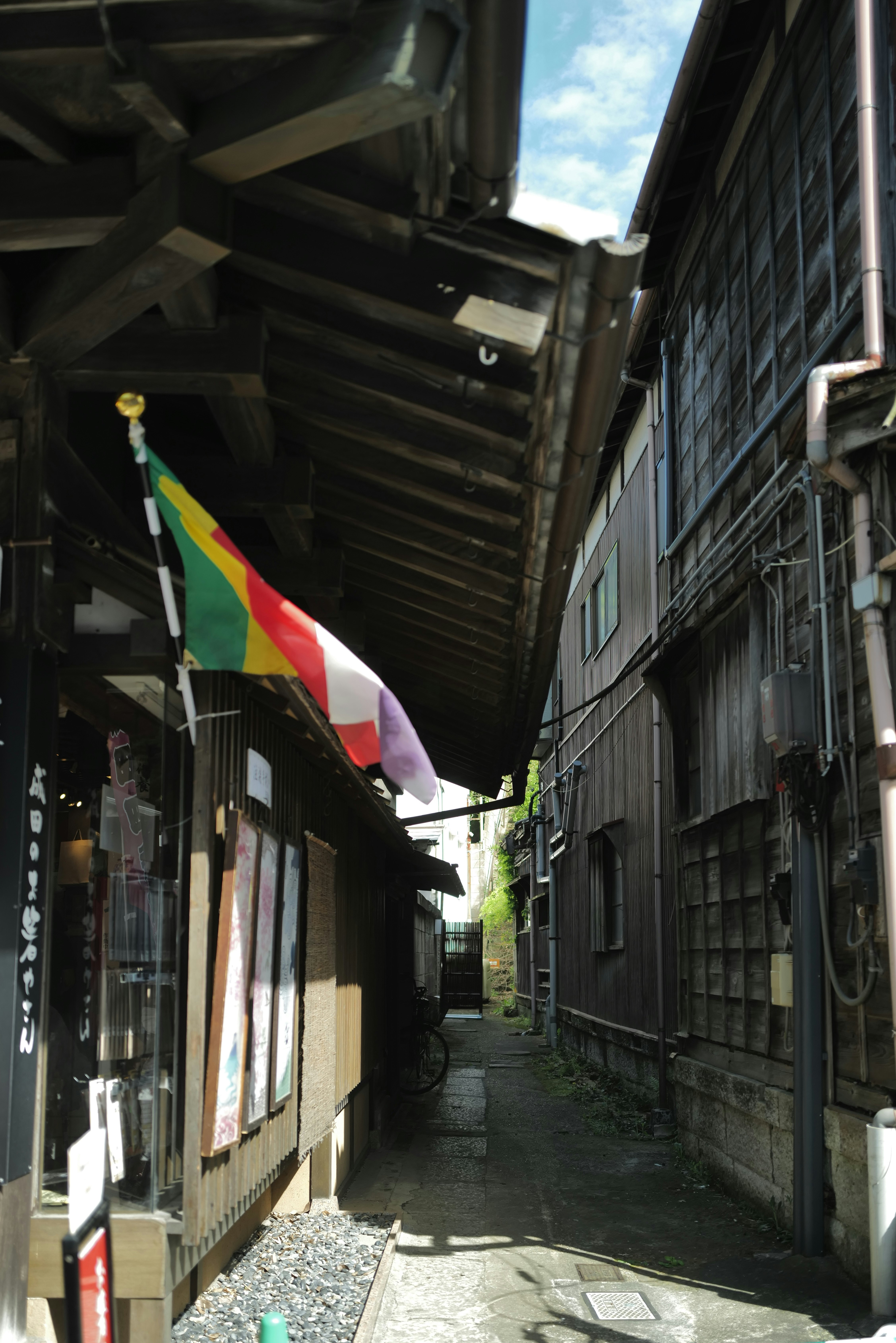 ruelle avec un drapeau national suspendu entre des façades