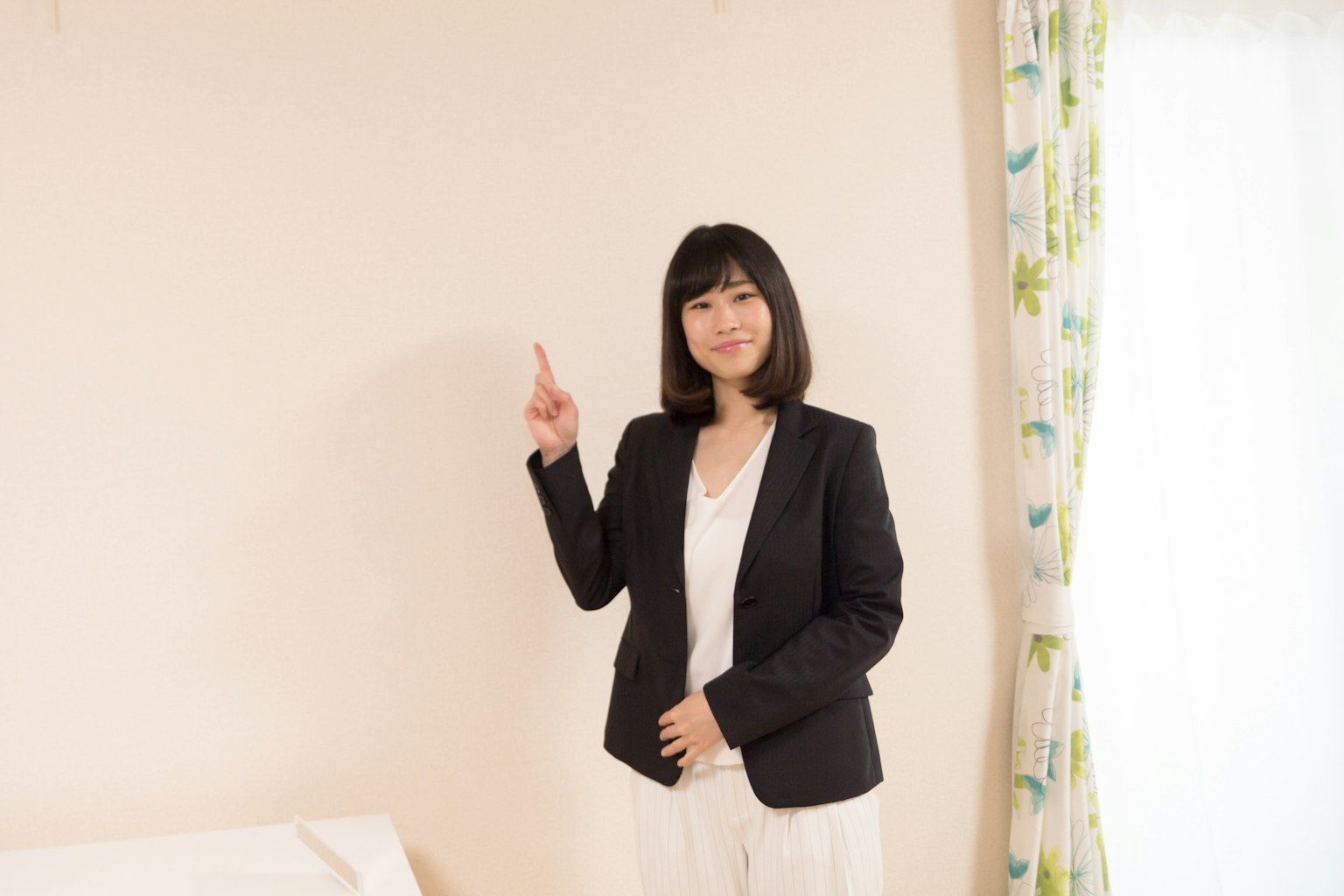 Femme en costume pointant dans un cadre intérieur lumineux