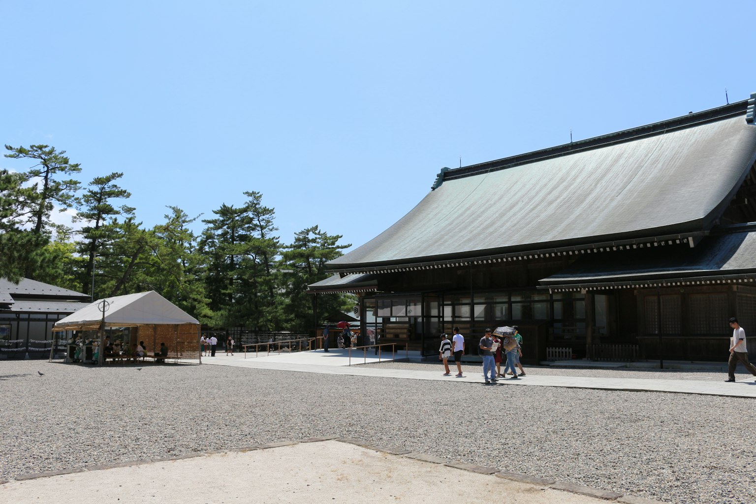 传统日本寺庙建筑，周围是宽敞的花园和人们