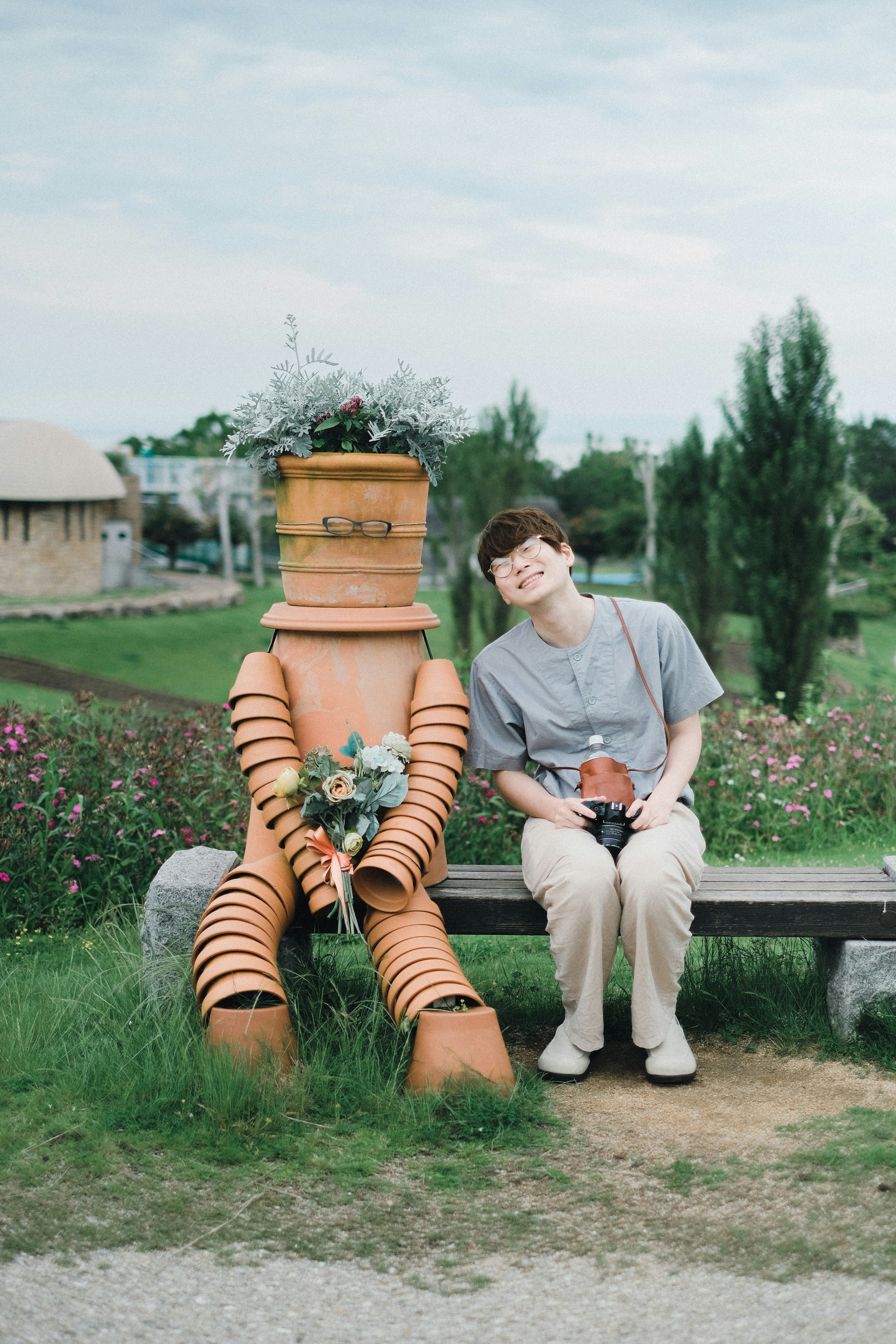 smiling child with a flower doll on a bench in a flower field