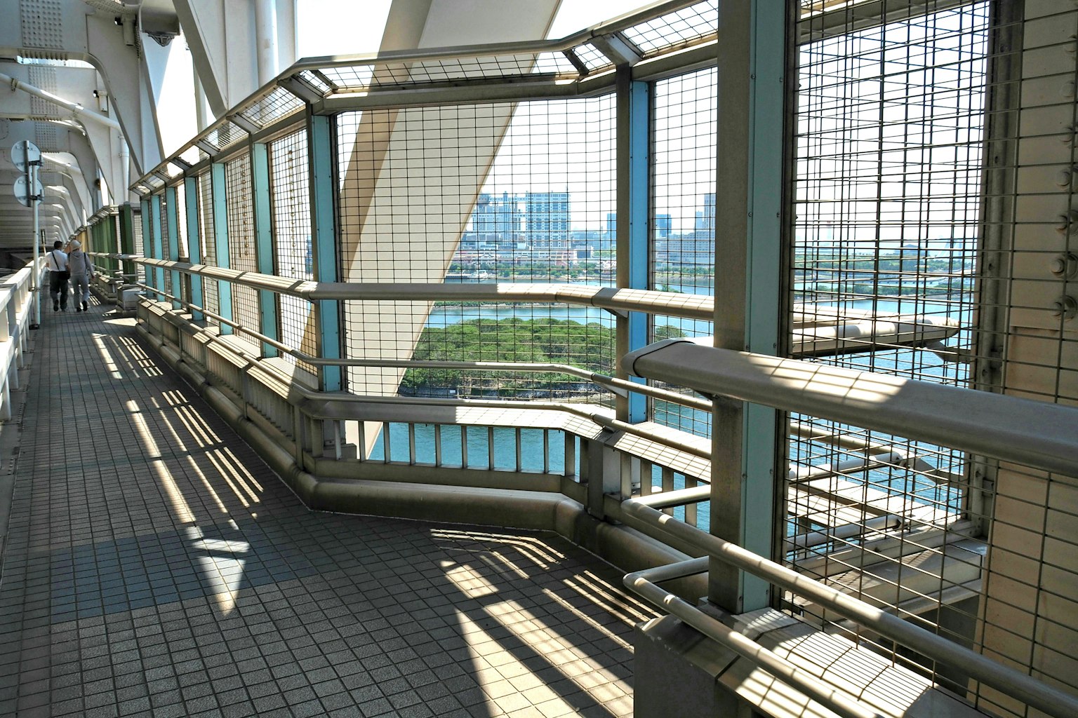 Foto di un ponte elevato con ringhiere e ombre proiettate dalla luce solare