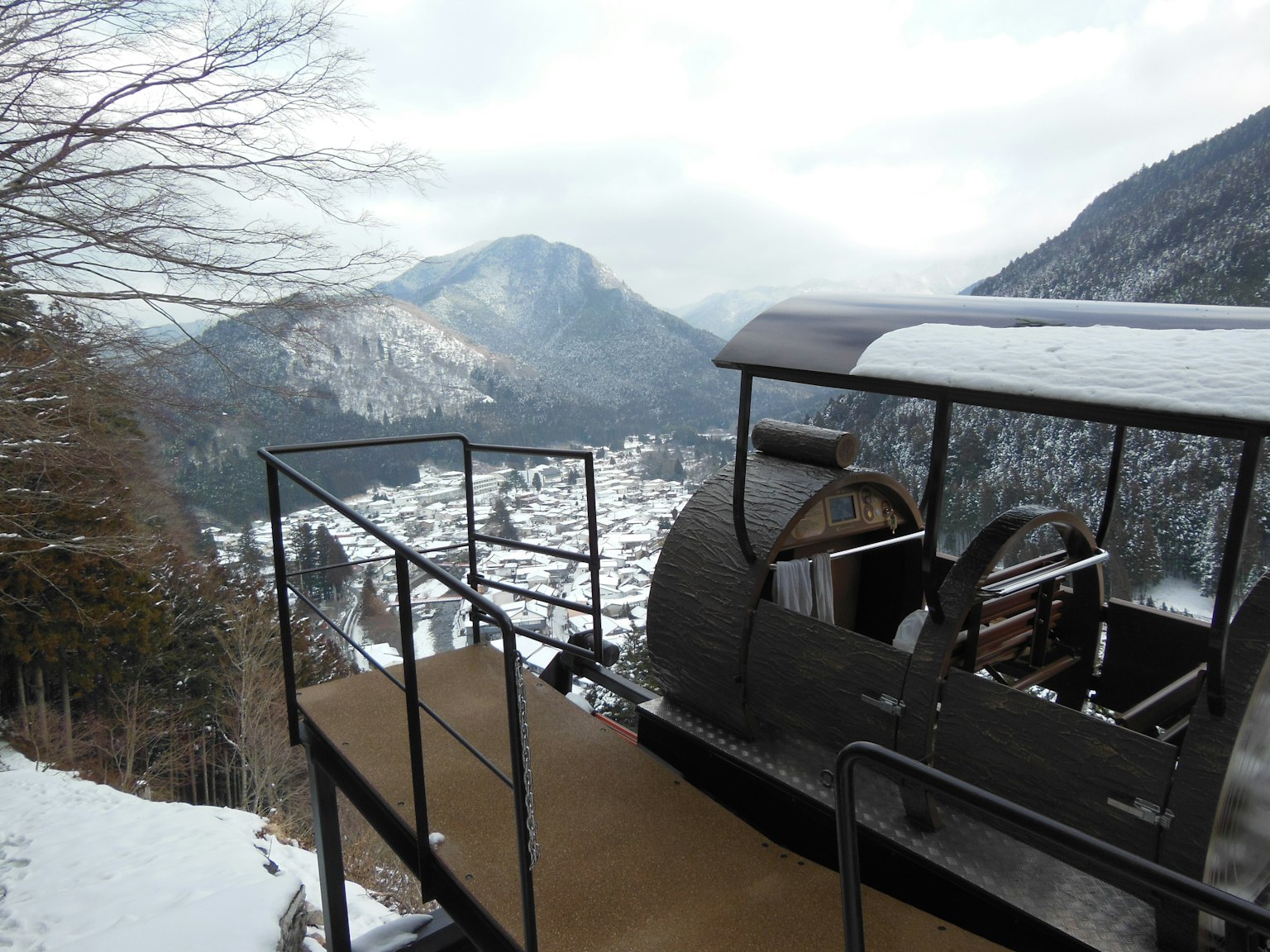 Piattaforma della funivia che domina montagne innevate e una valle