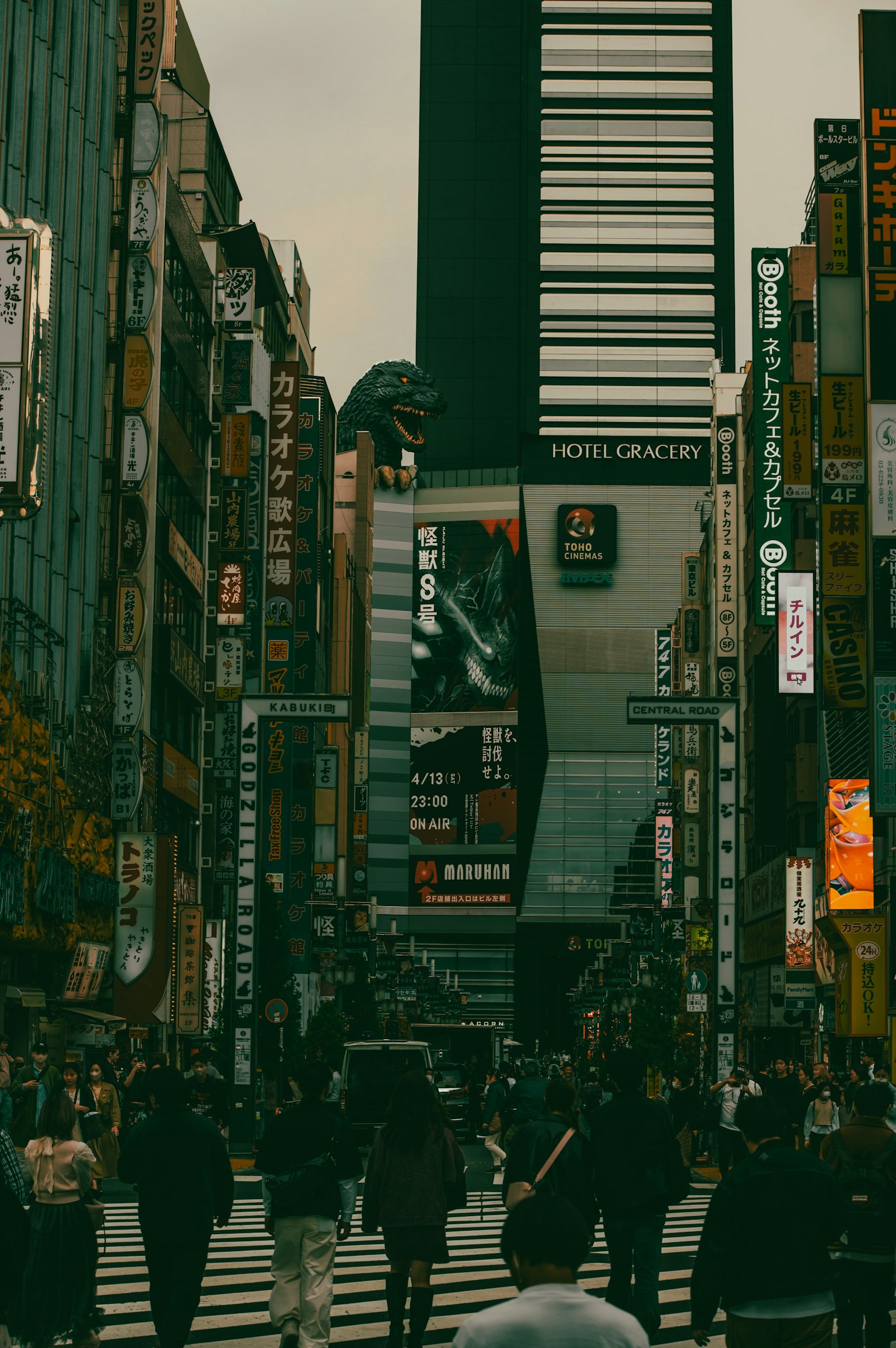 ถนนในเมืองที่คึกคักมีผู้คนข้ามถนนและอาคารสูงในพื้นหลัง