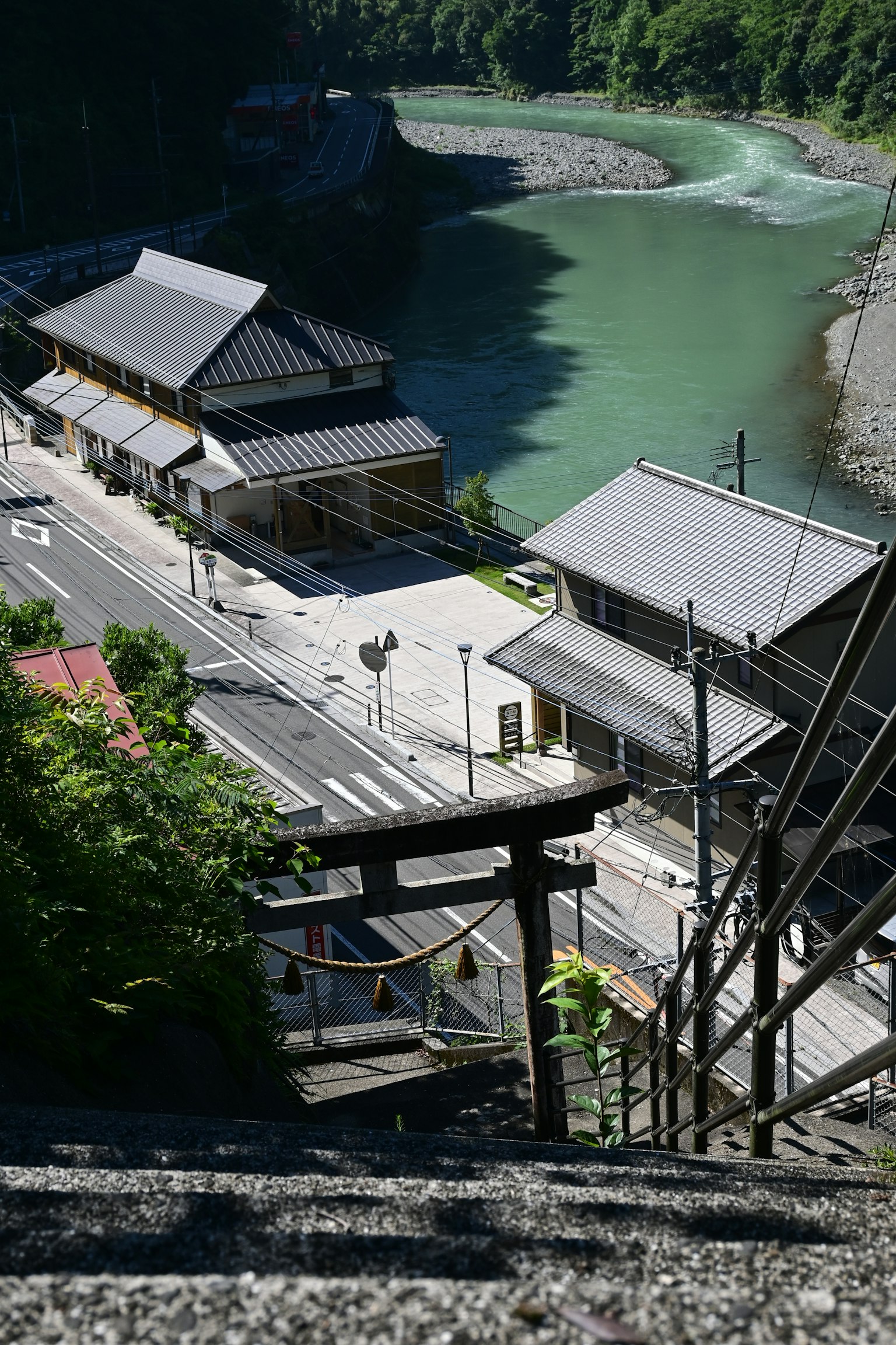 Malersicher Blick auf traditionelle japanische Gebäude an einem Fluss mit einem Torii