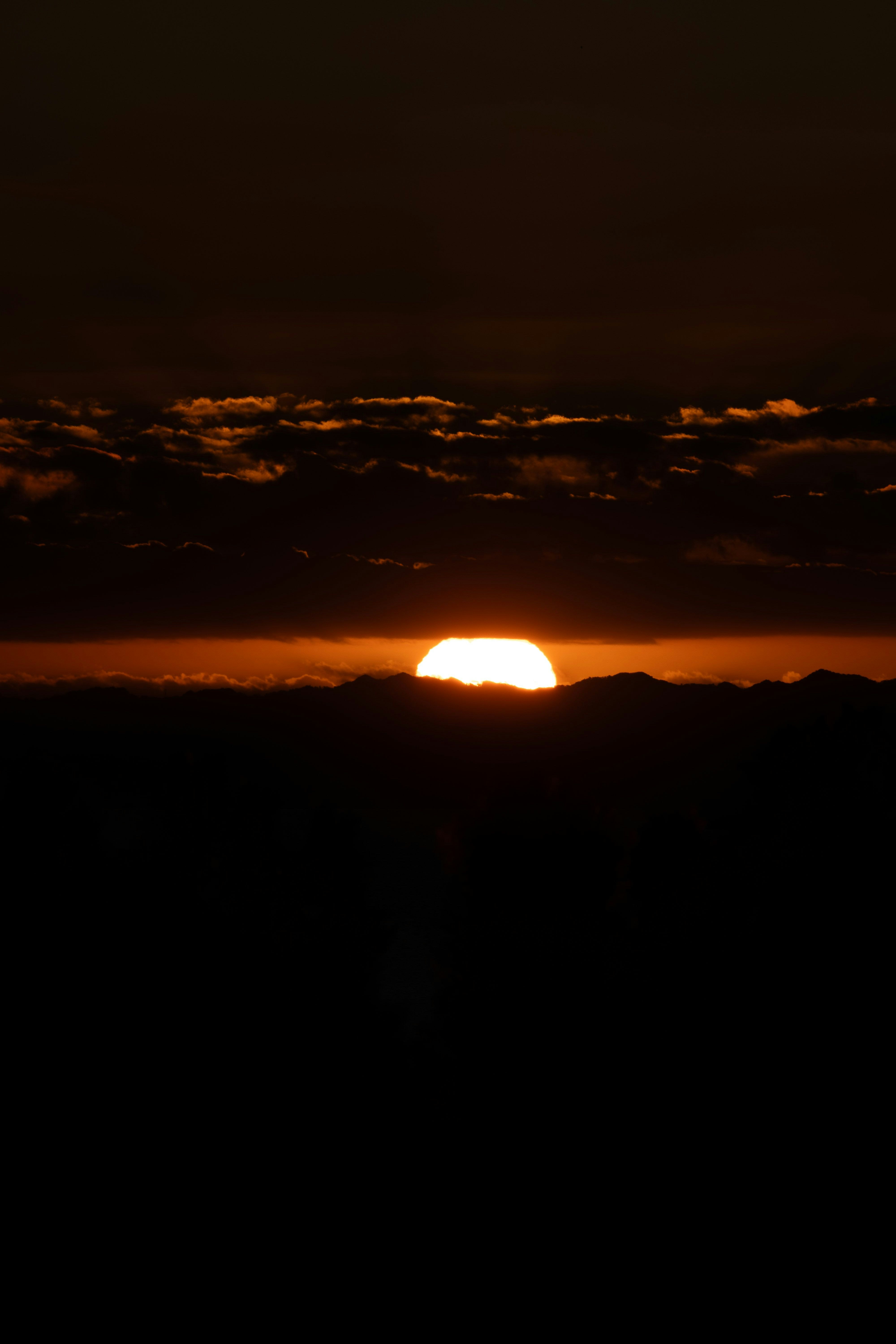 雲の向こうから昇る夕日
