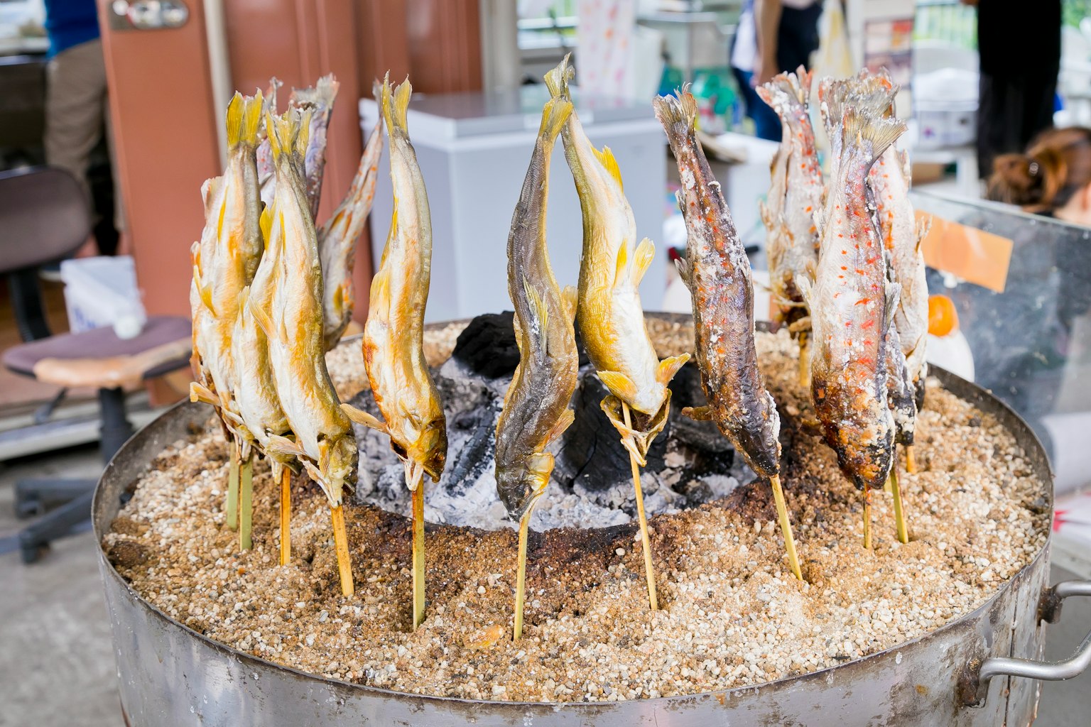 Pescado a la parrilla en brochetas exhibido en un puesto de comida