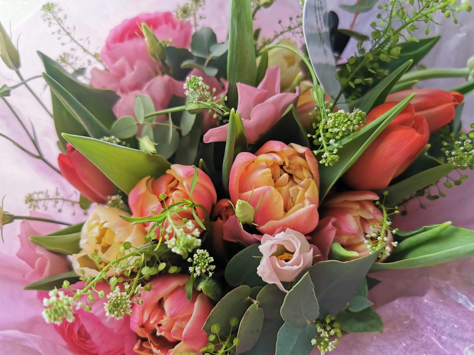 Un ramo vibrante con tulipanes variados y vegetación