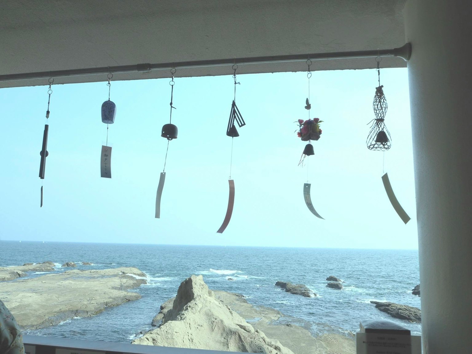 海景背景下的风铃展示多种形状的装饰在风中摇摆