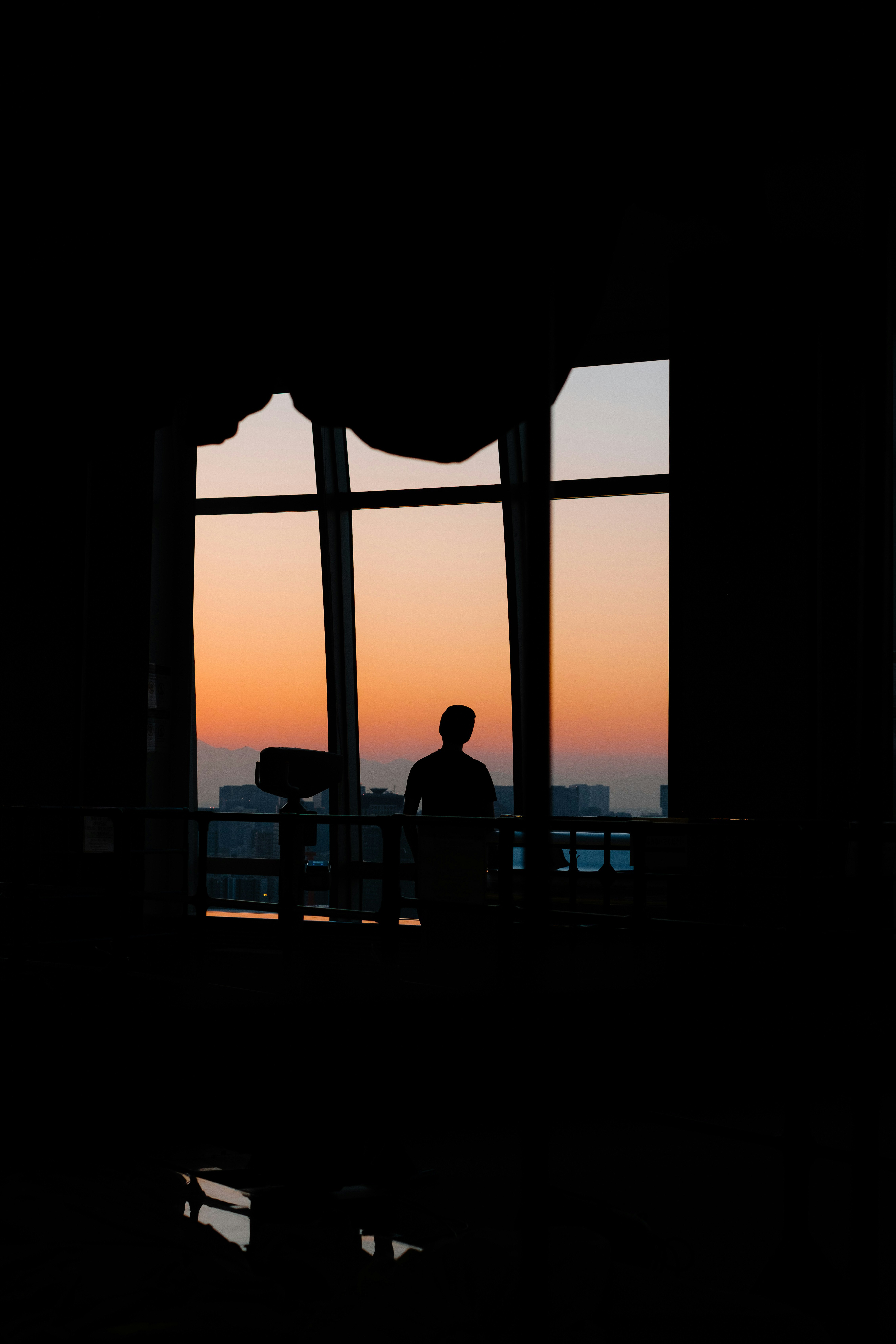 Silhouette by a window overlooking sunset