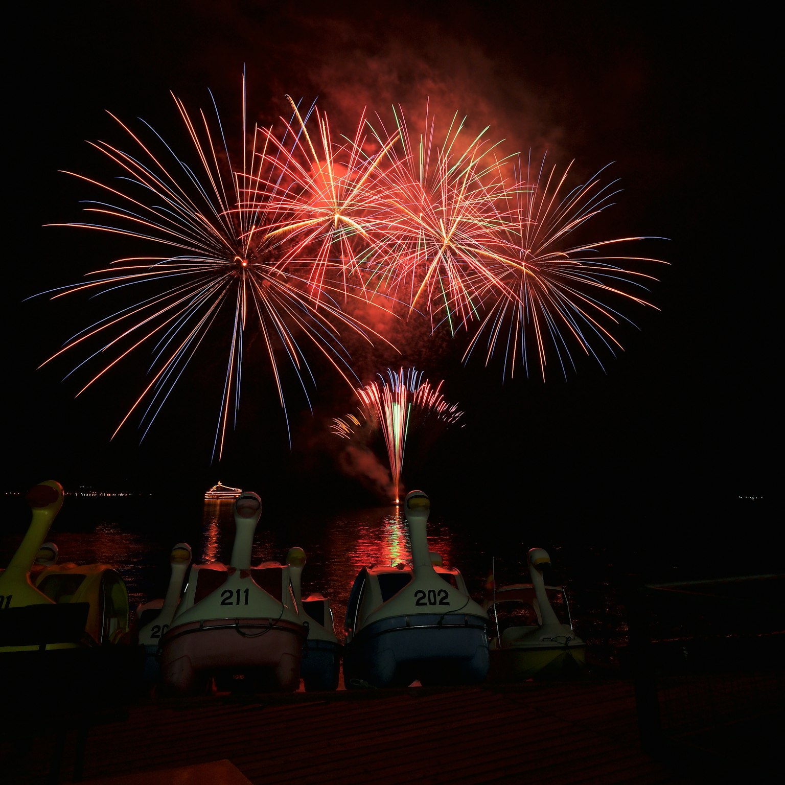 Colorful fireworks illuminate the night sky with vibrant bursts in the background colorful boats are lined up in the foreground