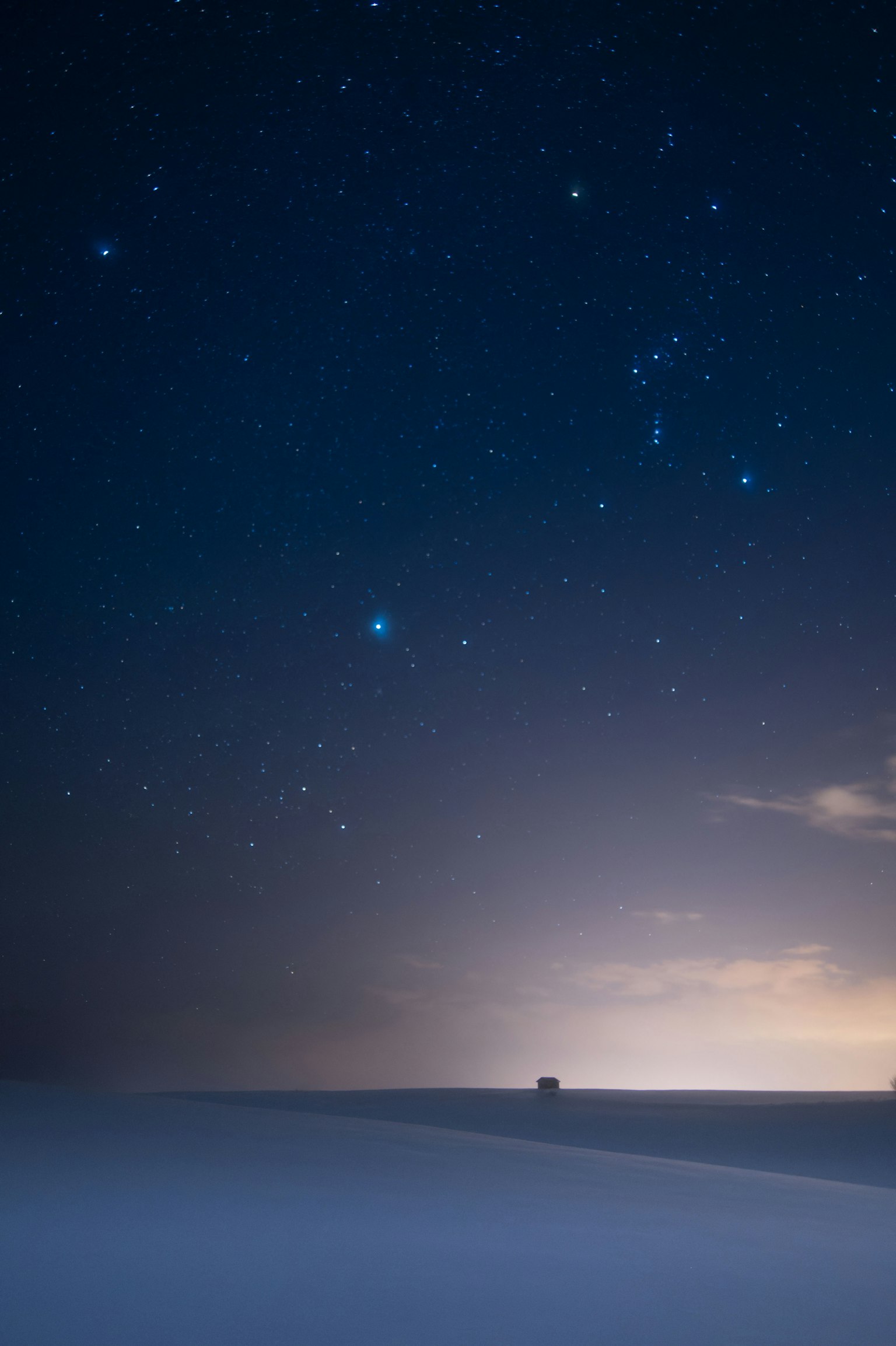 Landschaft mit sternenklarer Nacht und fernen Lichtern