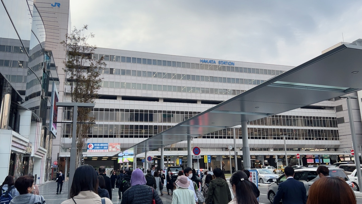 Außenansicht eines großen Bahnhofs mit vielen Fußgängern