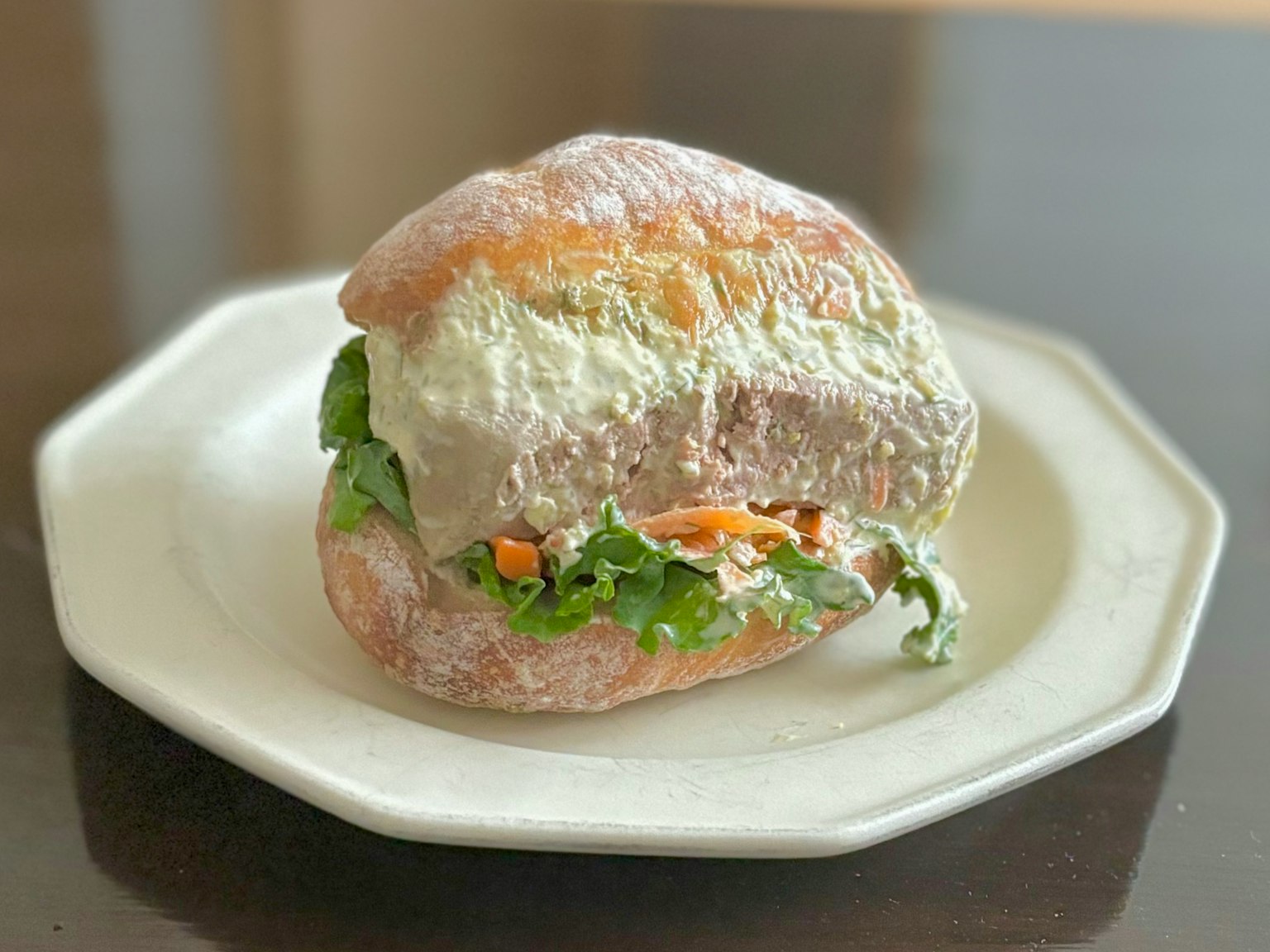 Một chiếc sandwich đặt trên đĩa với rau và nguyên liệu tươi