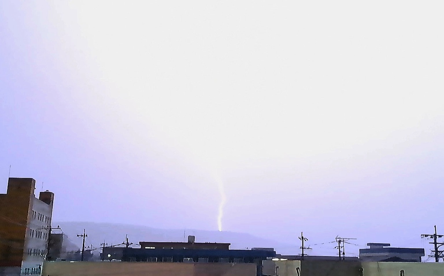 Blitz schlägt in einen bewölkten Himmel über Gebäuden ein